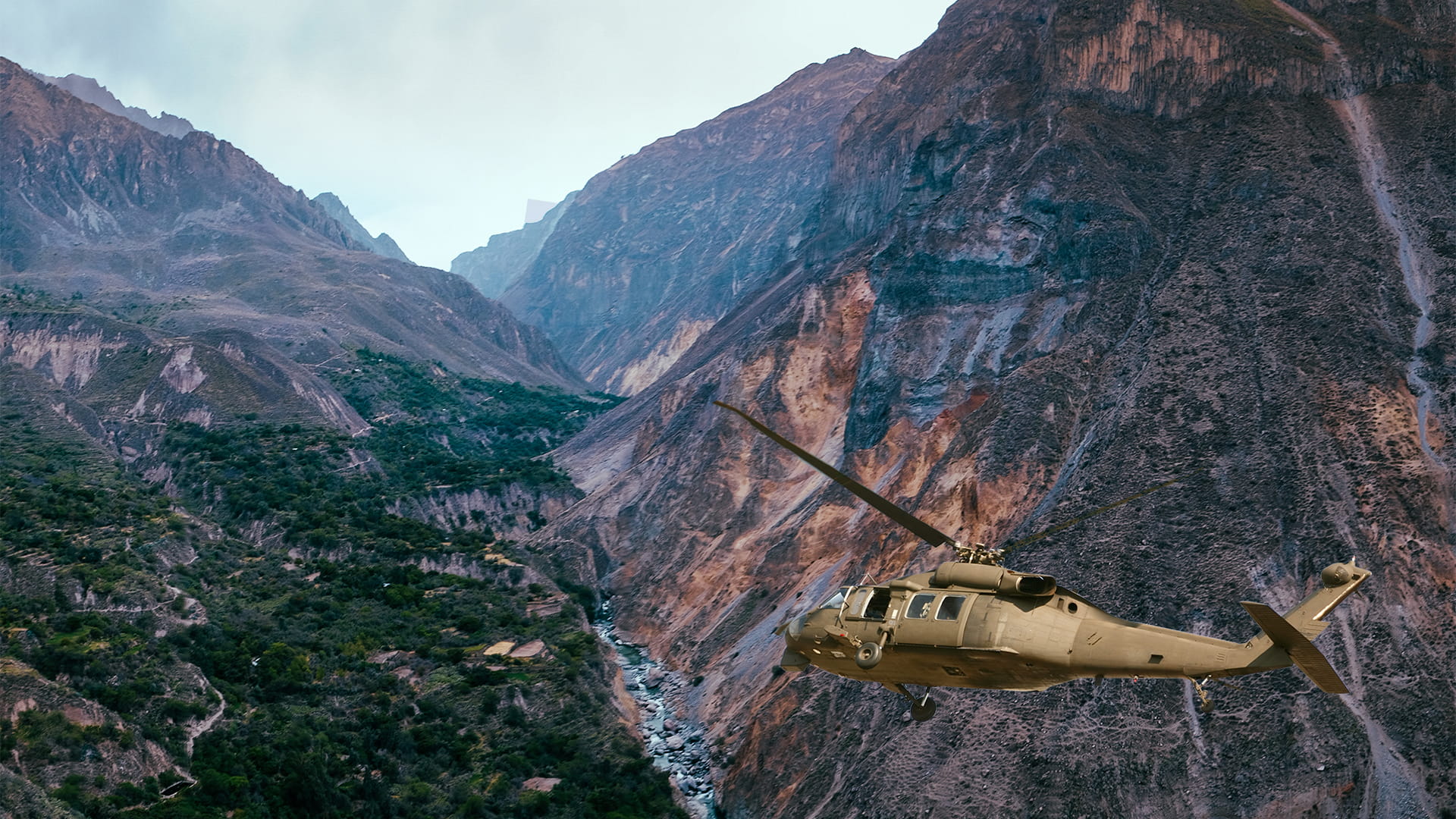 Helicopter flying through mountains and valleys