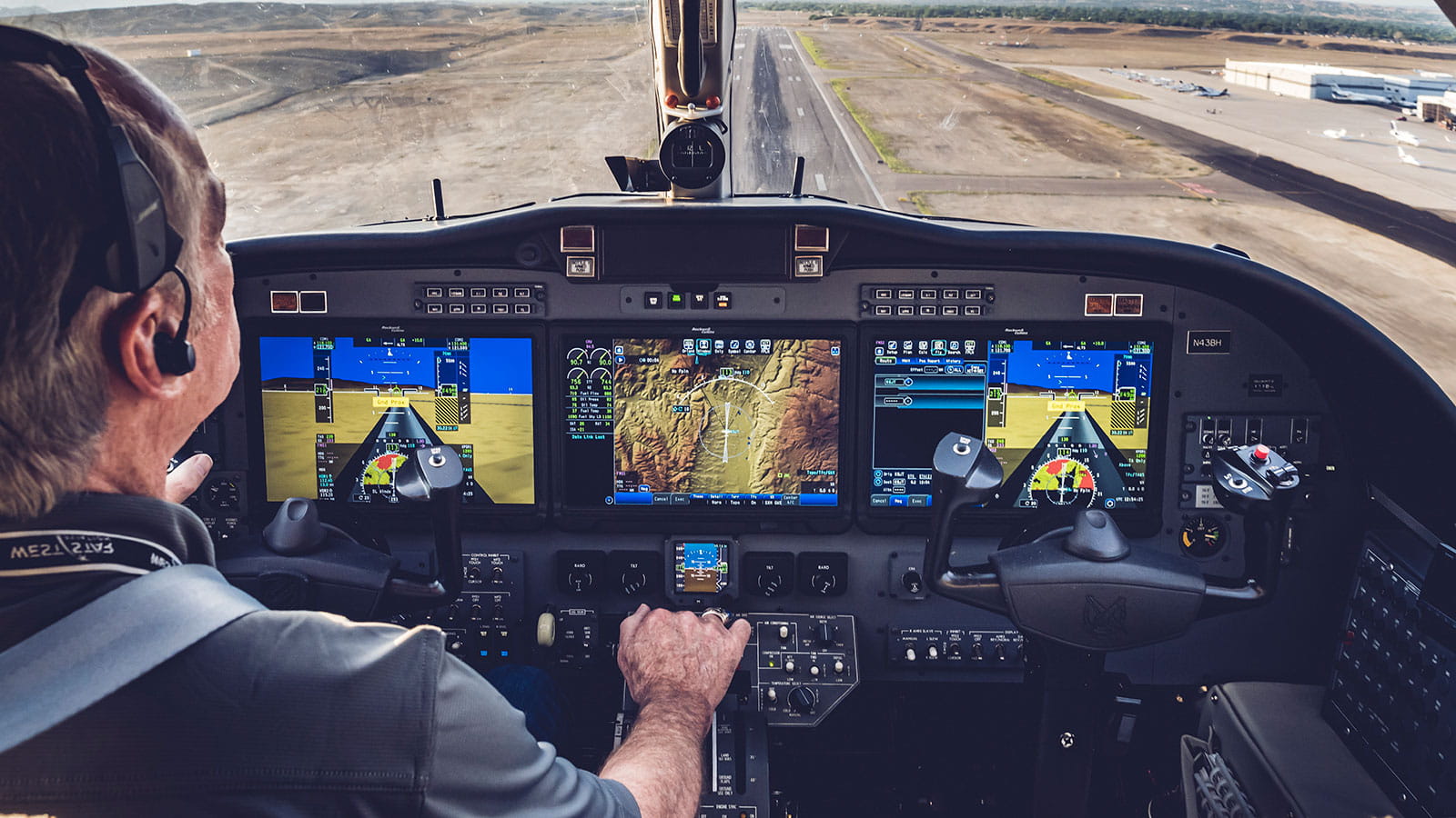 A pilot with his hand on the throttle. Collins displays 