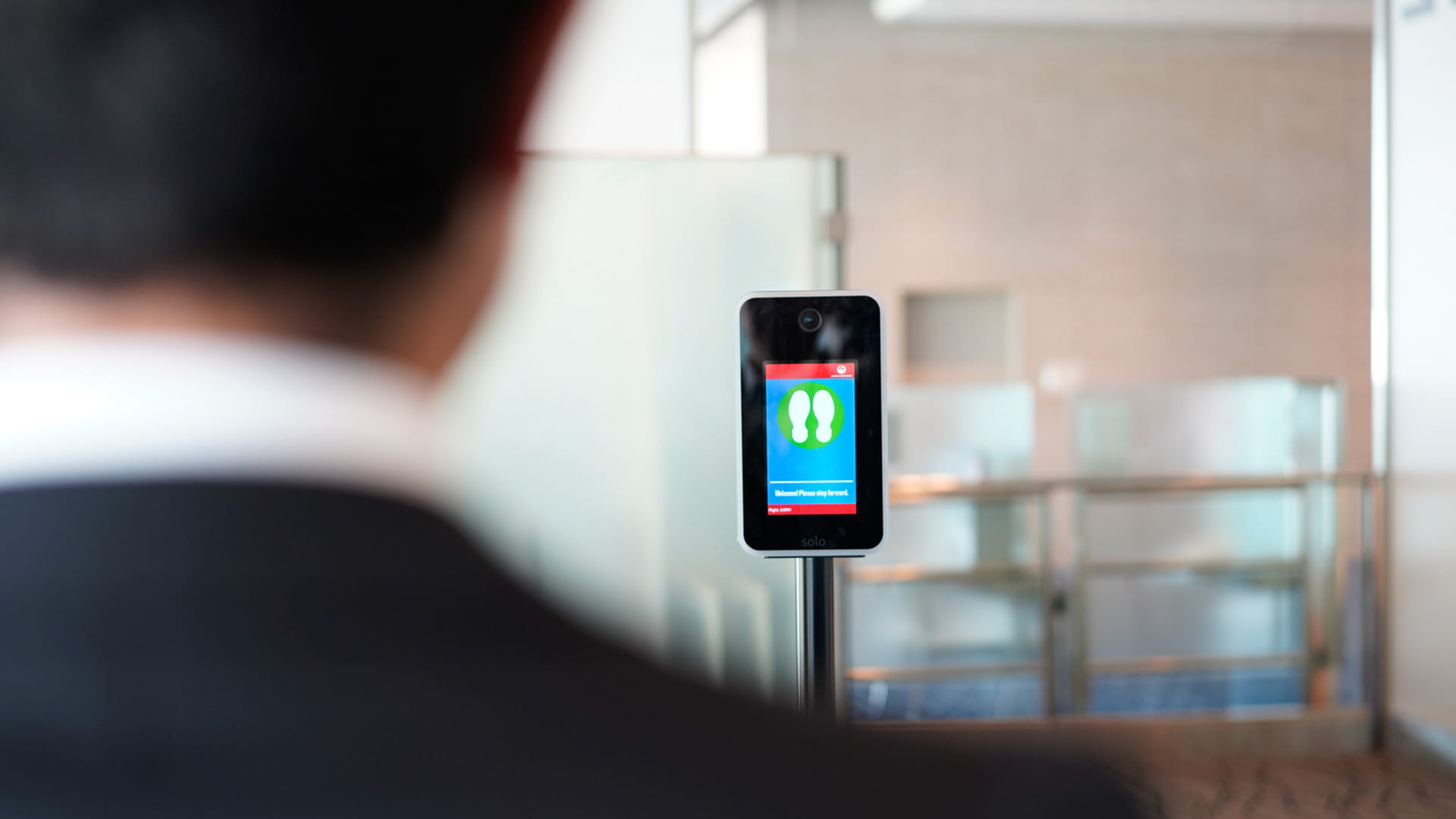 A person interacts with an airport biometrics device