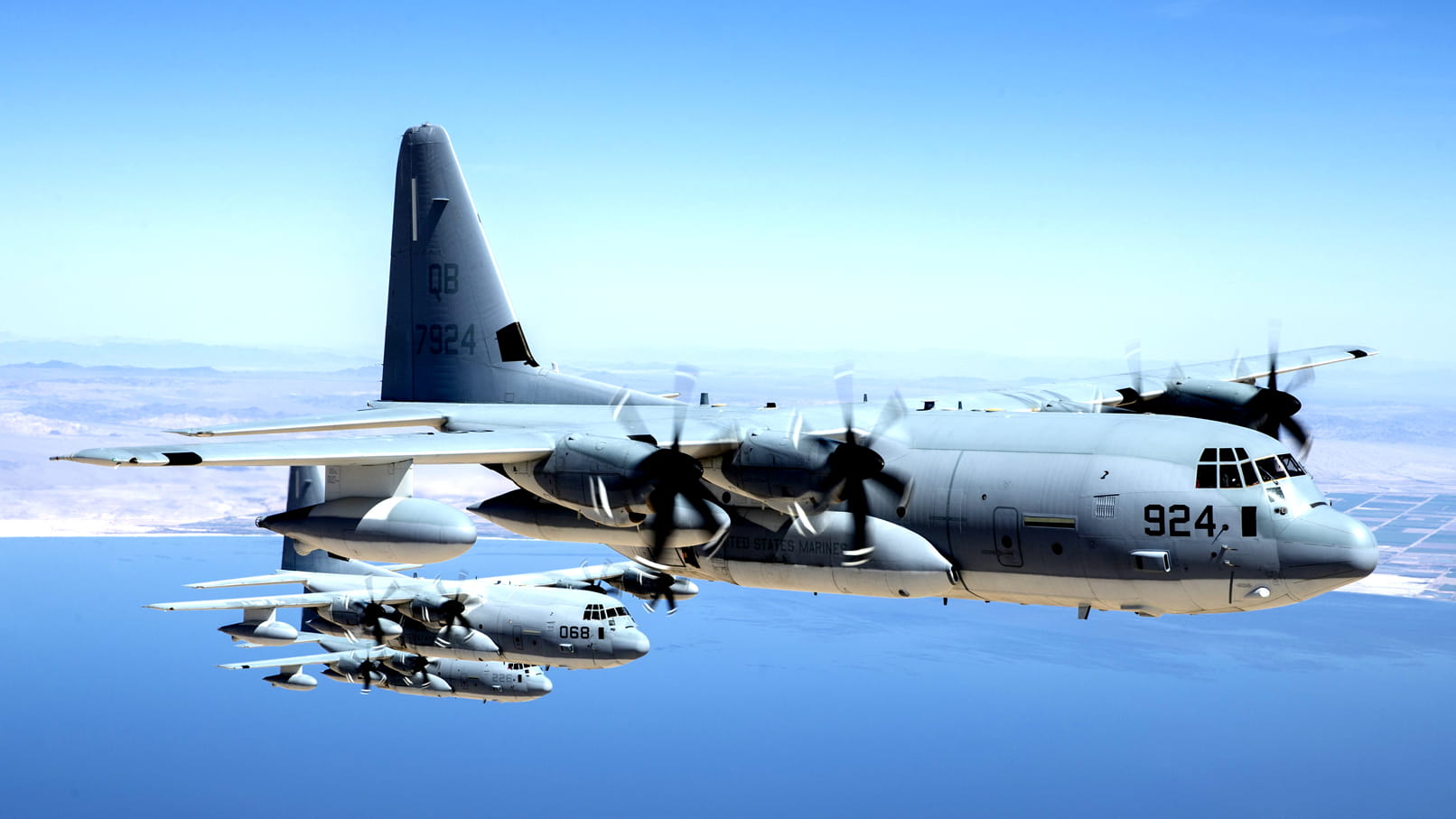 Military C-130 planes flying together