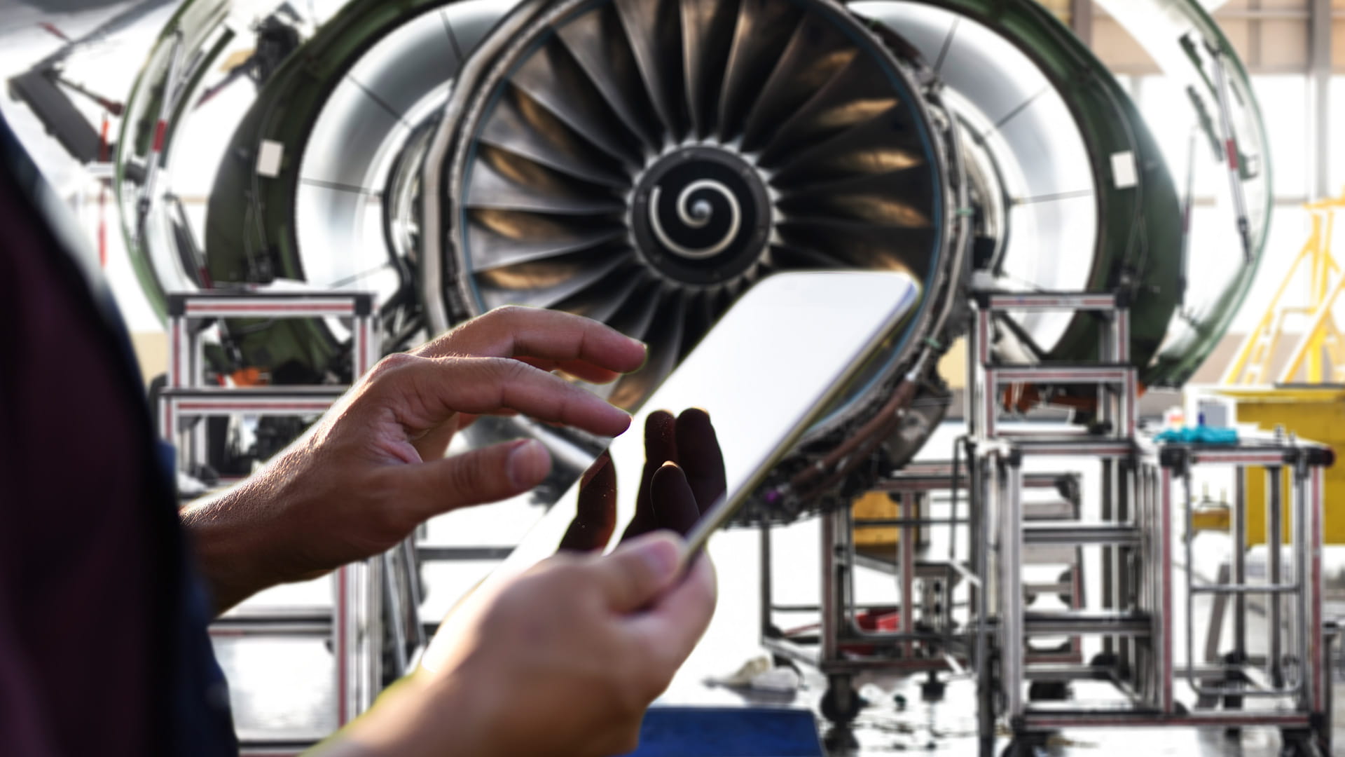 Person holding tablet with nacelle in background