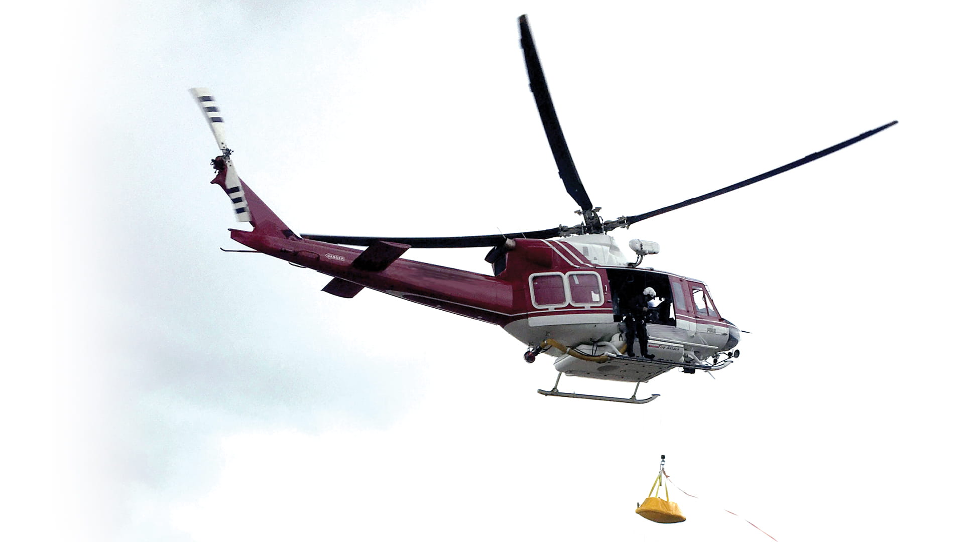 a helicopter flying with a rescue hoist