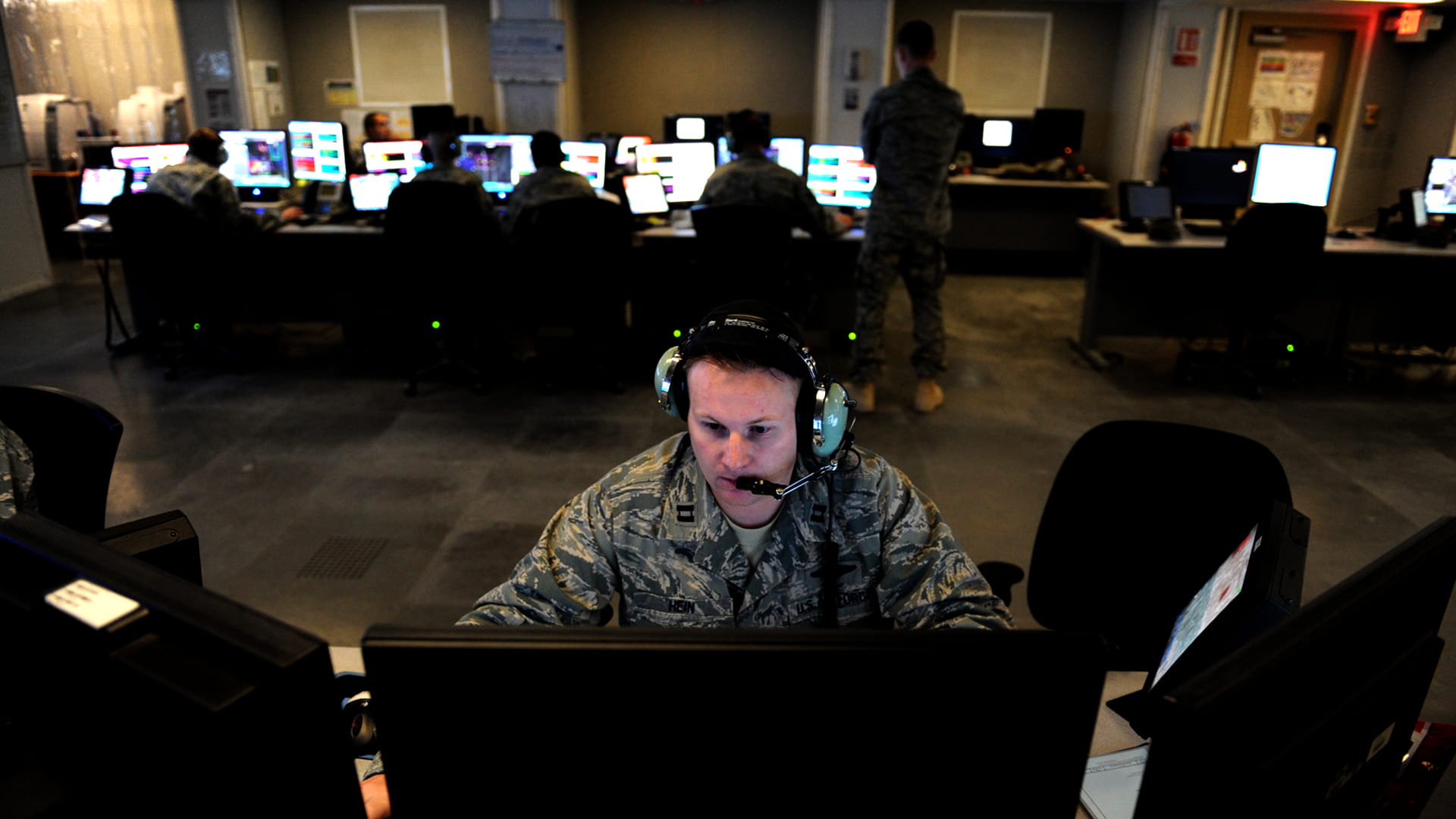 Collins Aerospace’s SecureOne™ high assurance center with solider sitting at desk with monitors