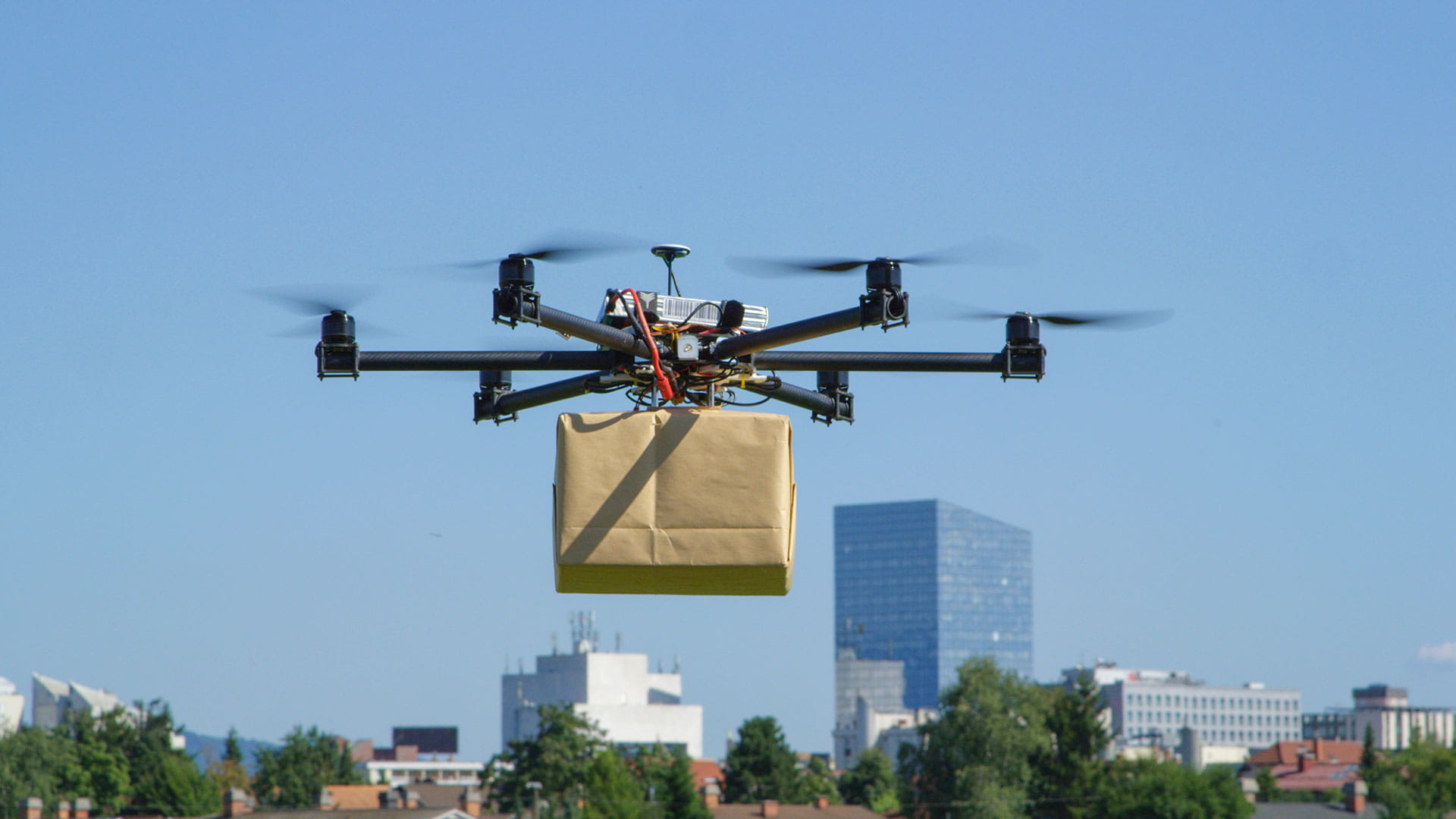 unmanned aerial vehicle delivering a package in the city