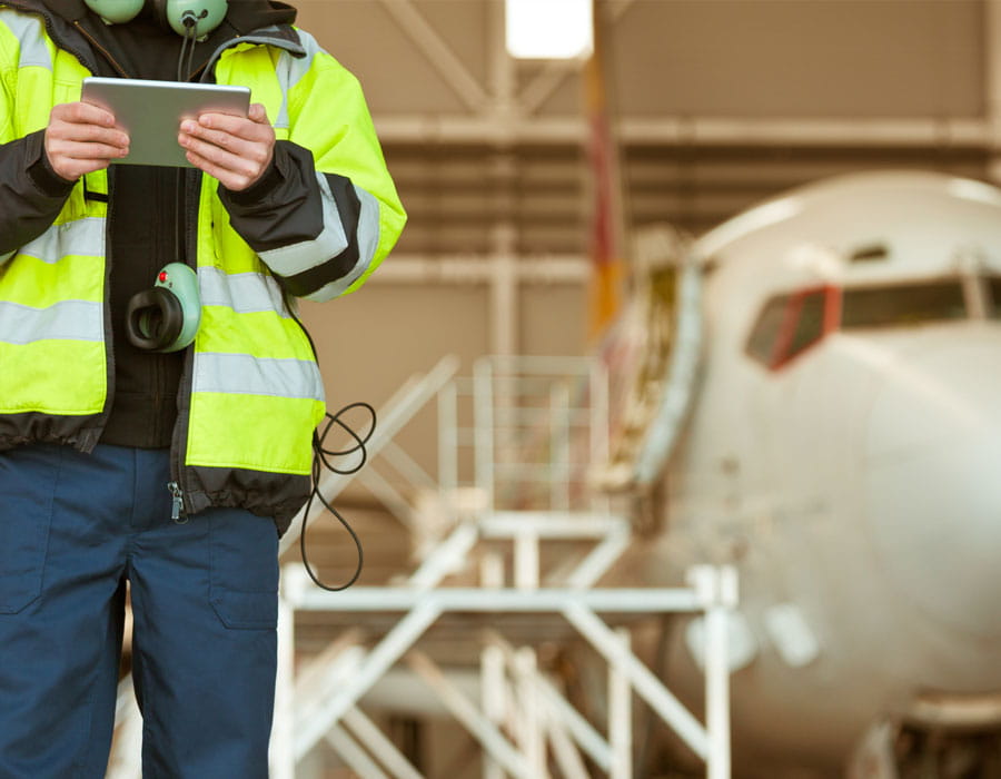 a man in a hangar standing in front of an airplane