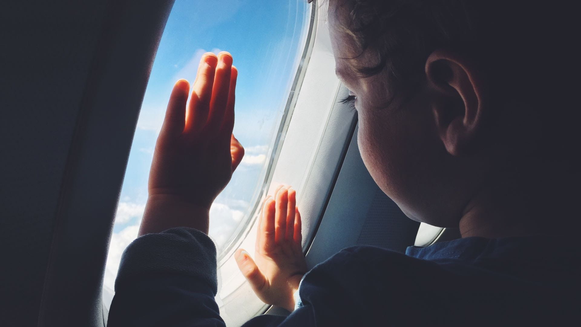 a child looking through the airplane window