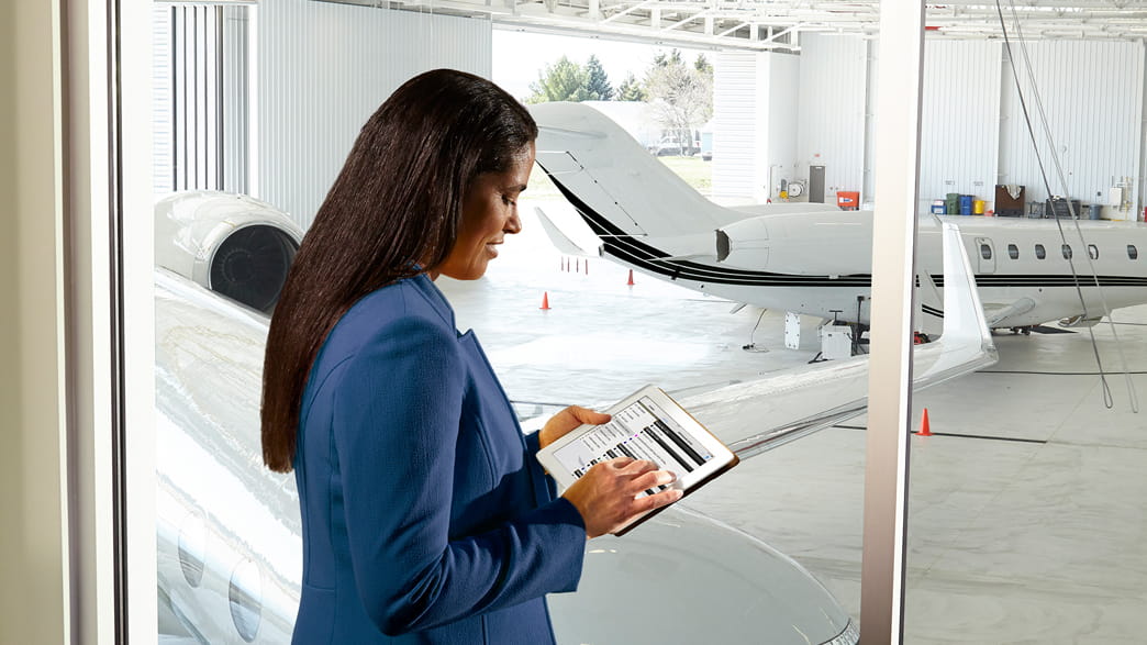 woman holding a tablet at the airport hangar