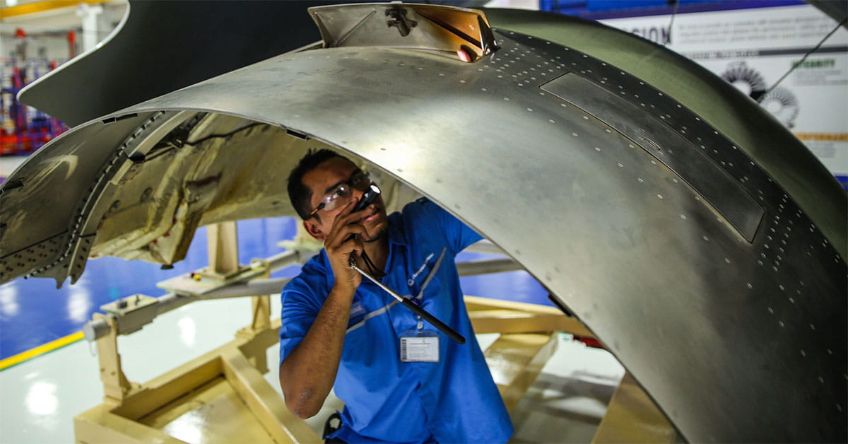 A technician inspects an aircraft component