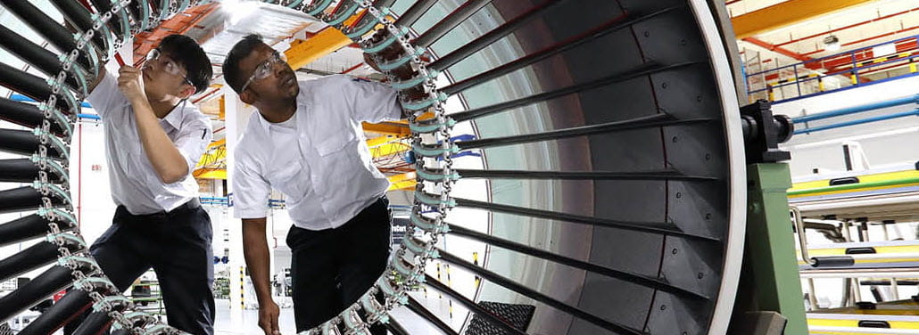 Two technicians work inside an engine