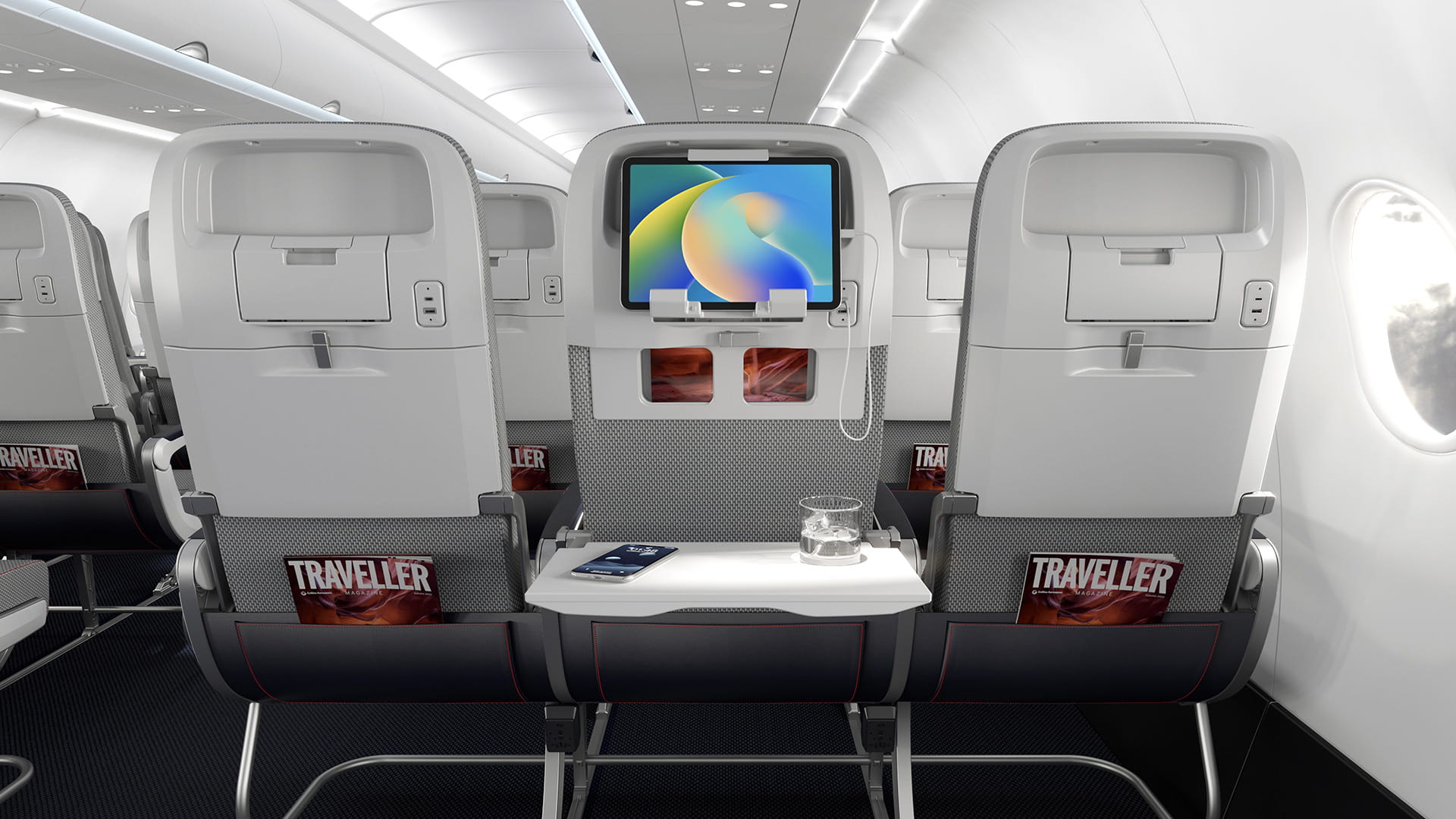 The backs of three aircraft seats. A tablet is held in place on the upper portion of the middle seatback, and the tray table is down.