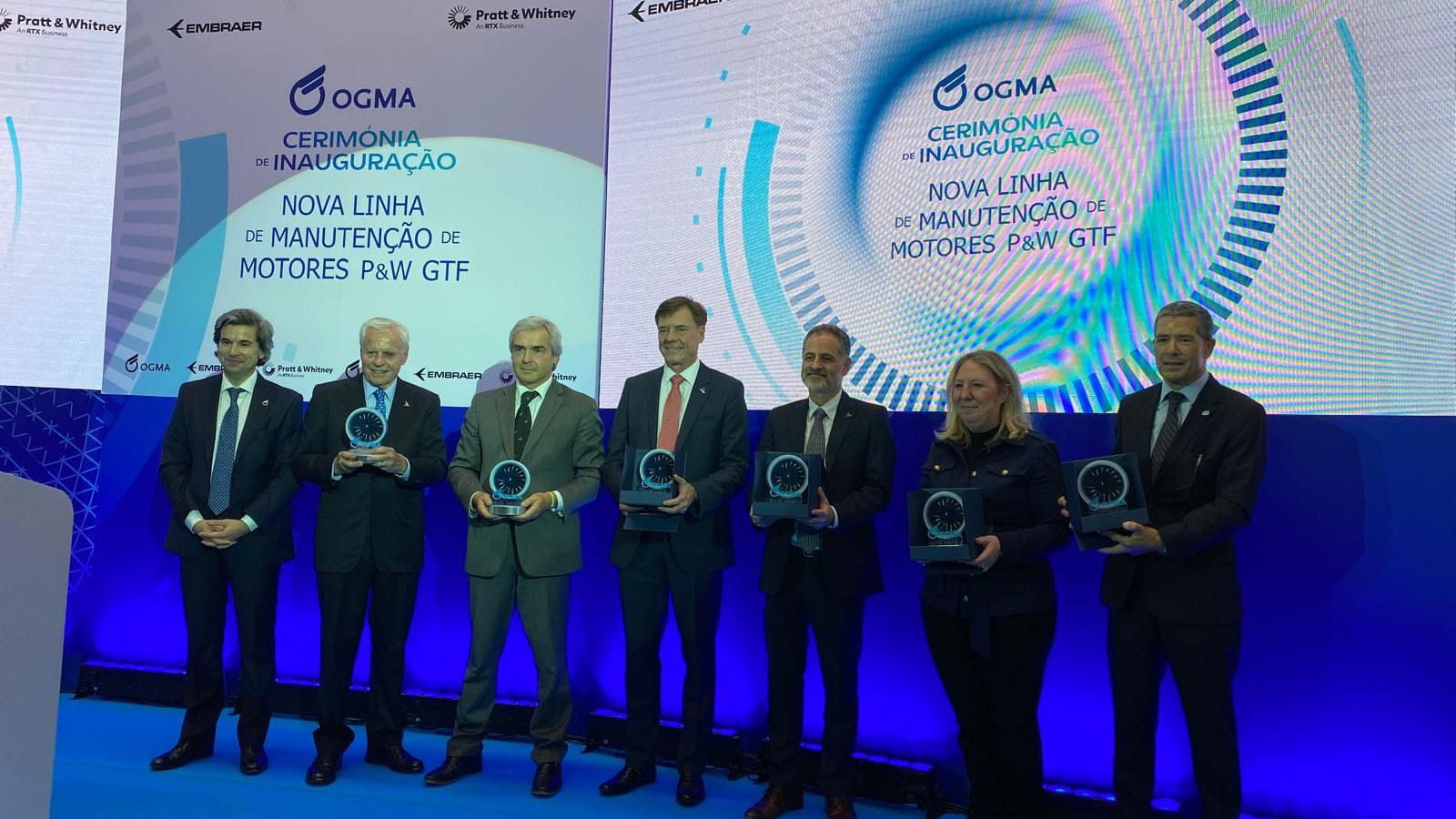 From L to R: Paulo Monginho, CEO of OGMA; Alexandre Silva, Embraer Chairman of the Board of Directors; Portugal Minister of Defense, Nuno Melo; Francisco Gomes Neto, President & CEO of Embraer; Carlos Naufel, Chairman of the Board of Directors at OGMA; Amy Comer, Vice President of GTF Programs at Pratt & Whitney; and Carlos Félix, President of the IdD Board of Directors, commemorate OGMA's facility inauguration and induction of the first Pratt & Whitney GTF engine in Alverca, Portugal.
