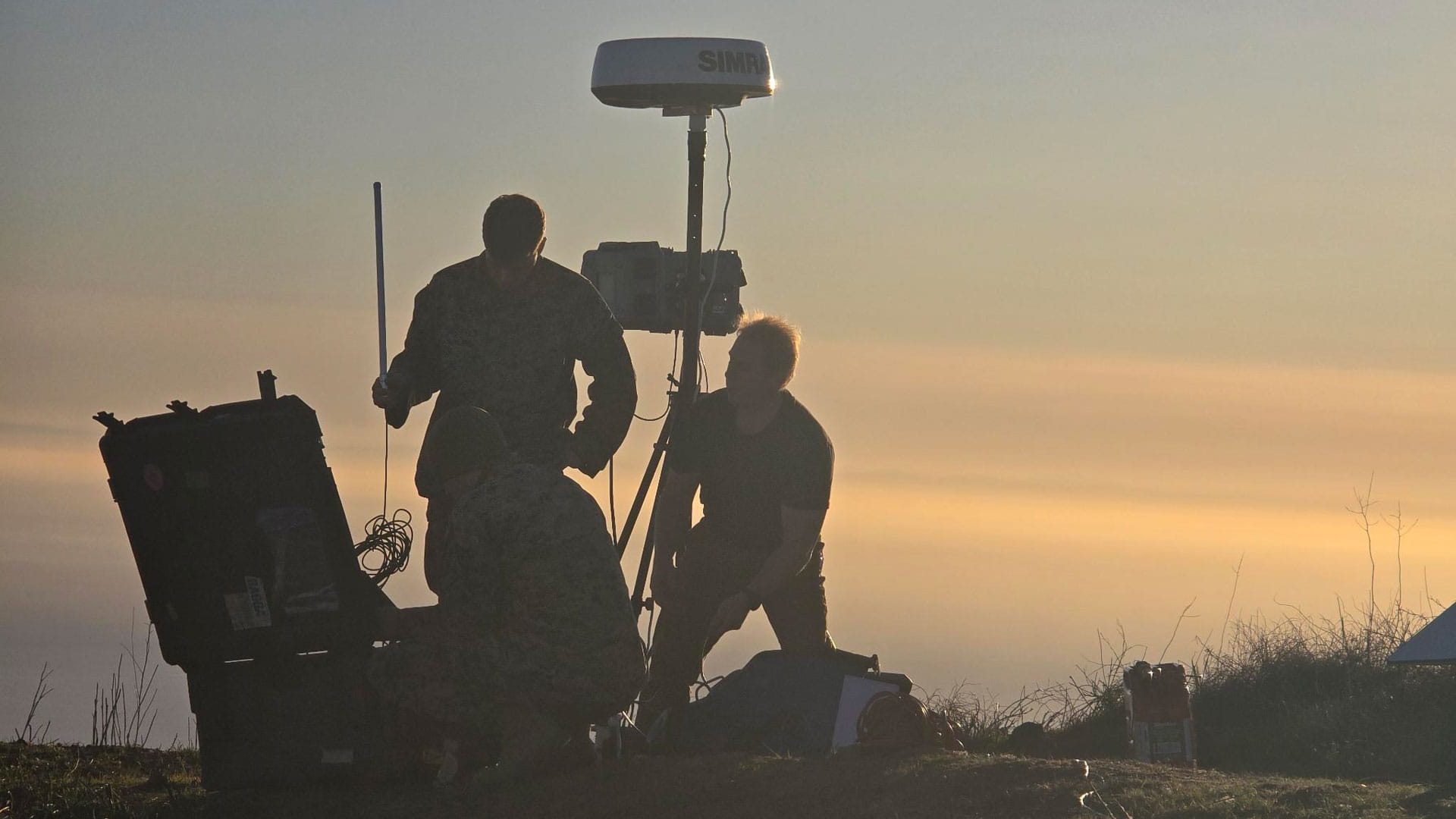 3 men working on a piece of equipment