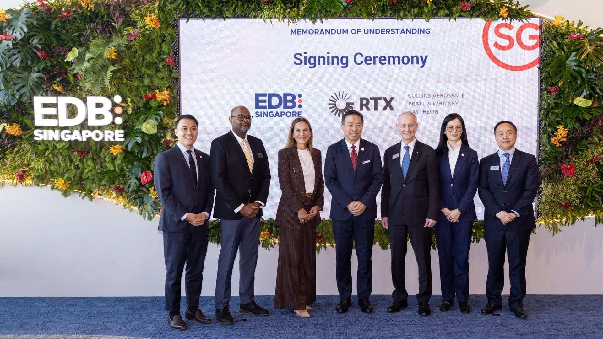 Men and women pose at a signing ceremony