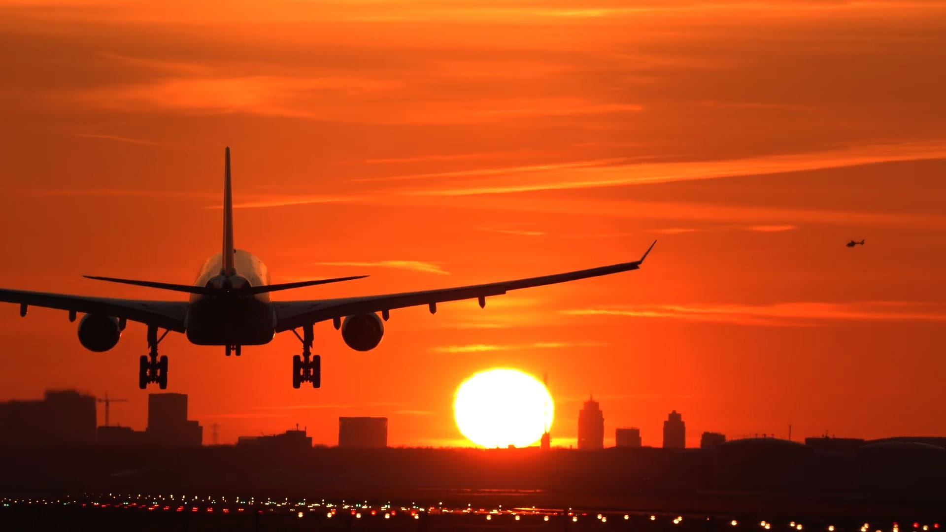 An airplane touching down at sunset