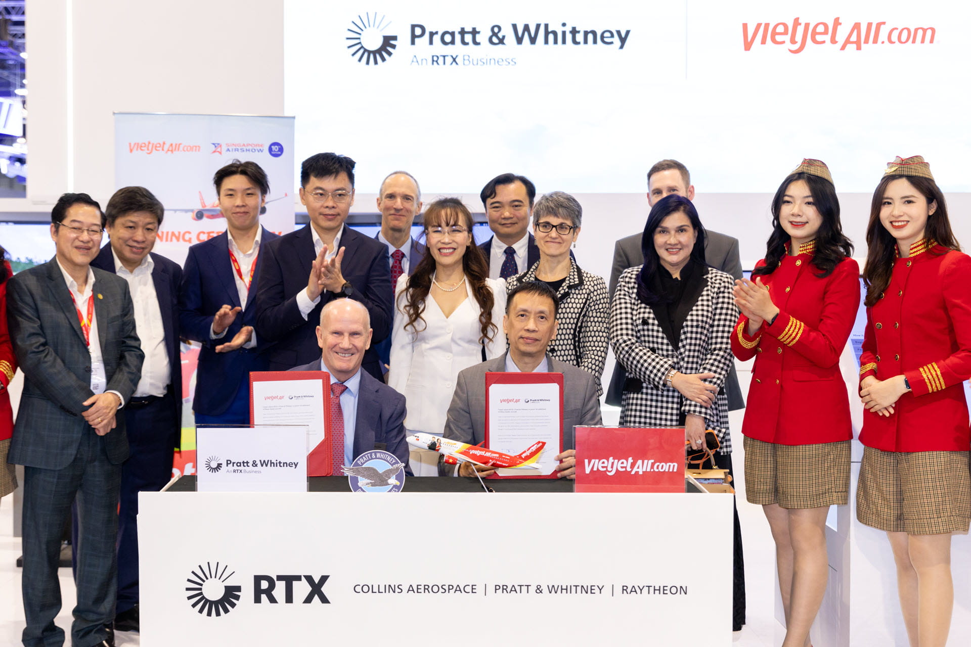 Employees of Pratt & Whitney and VietJet pose at a signing ceremony