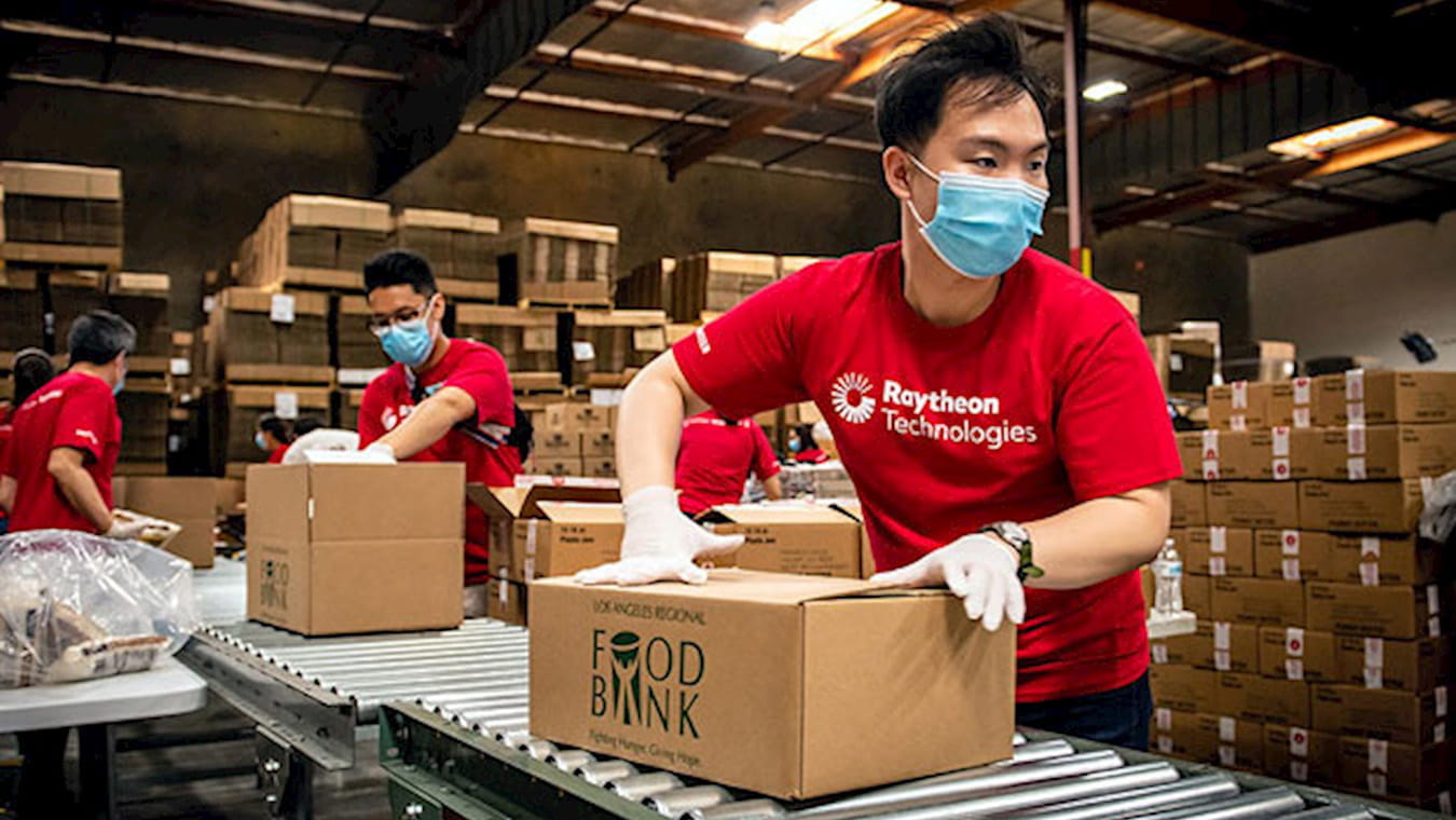 Raytheon Technologies employee packing boxes at the food bank