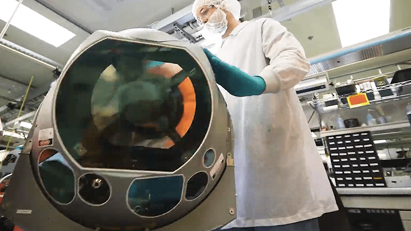 a laboratory engineer in white lab coat working on hardware