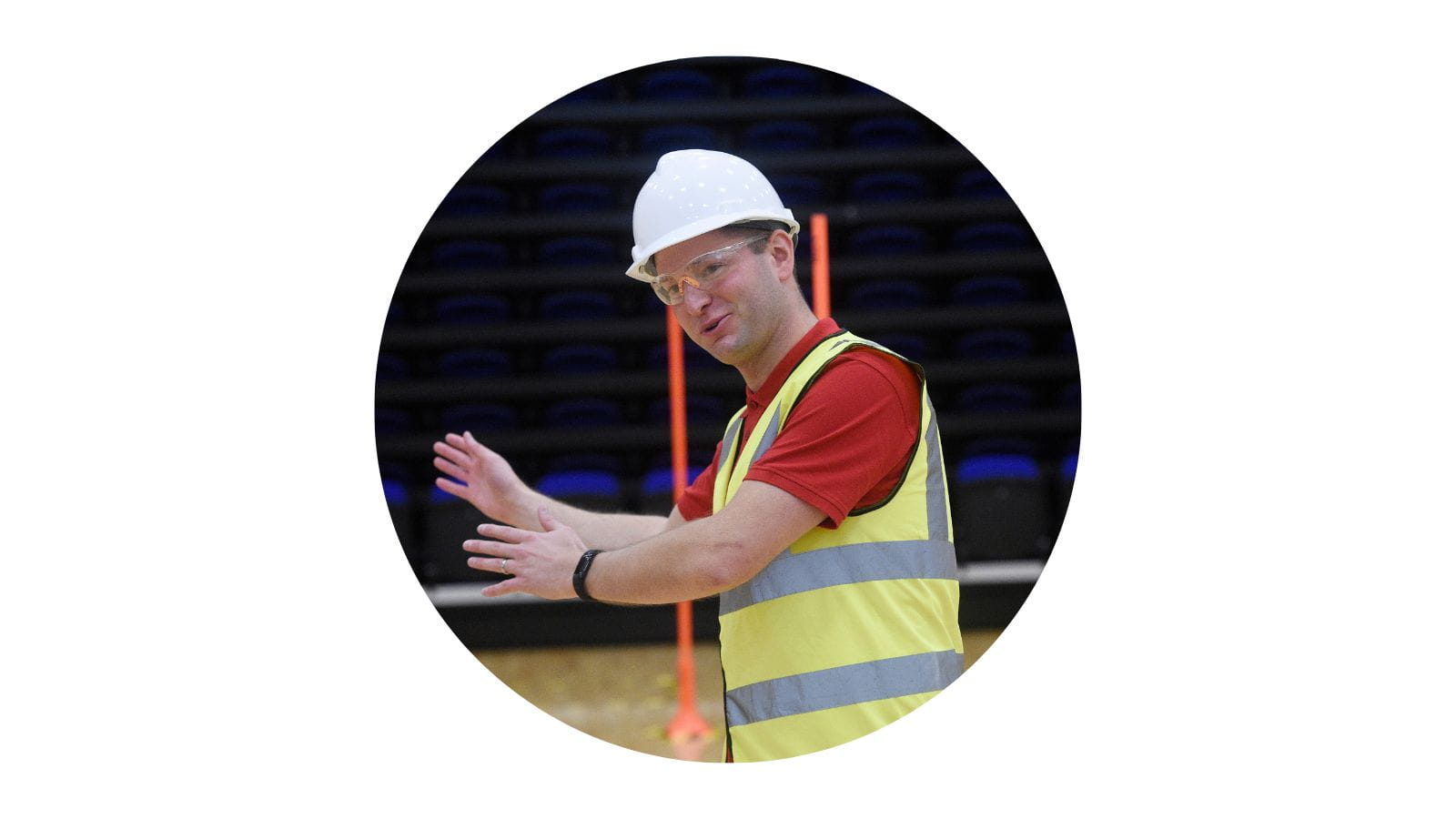 Man in a hard hat and high-vis vest directing a quadcopter