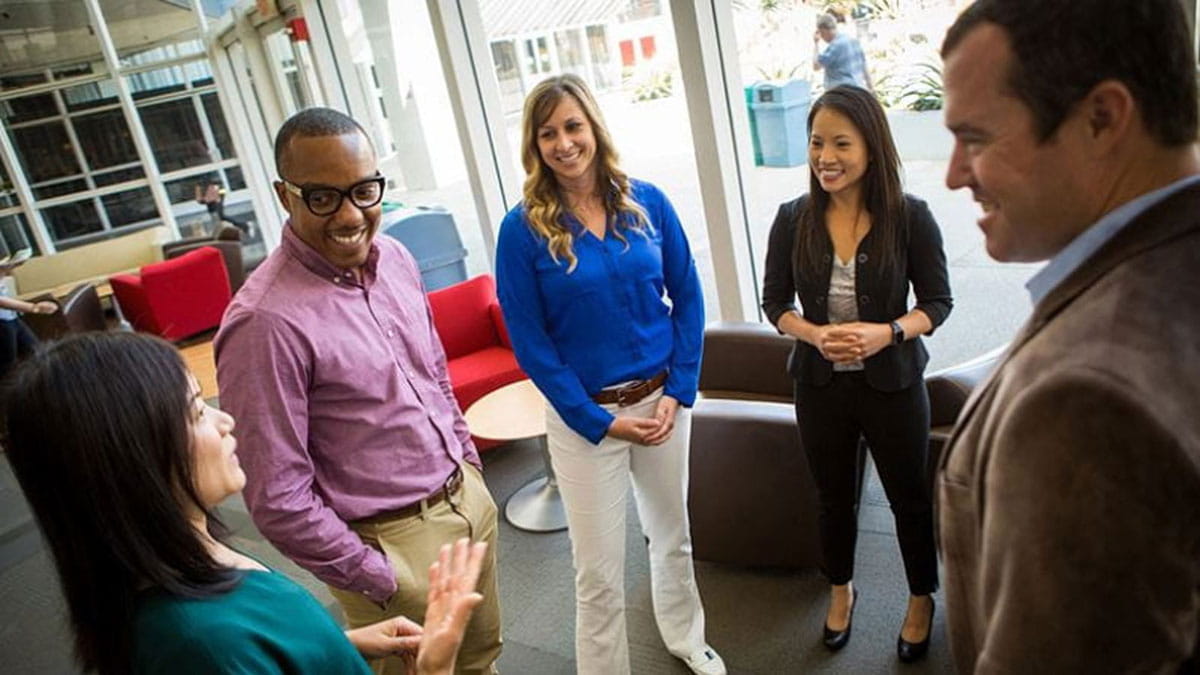 a group of office employees standing in a circle talking