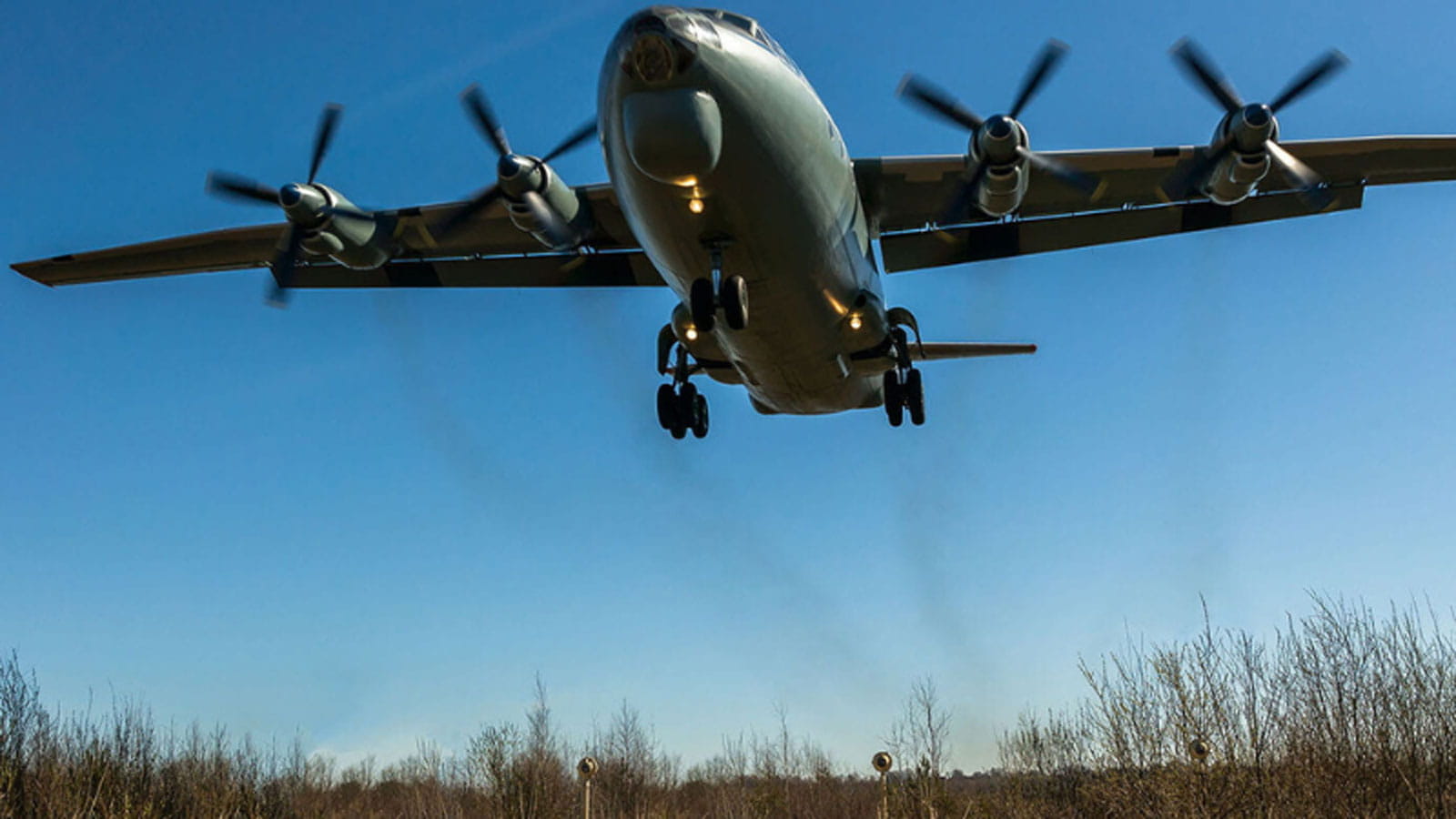 a propeller airplane flying above a field