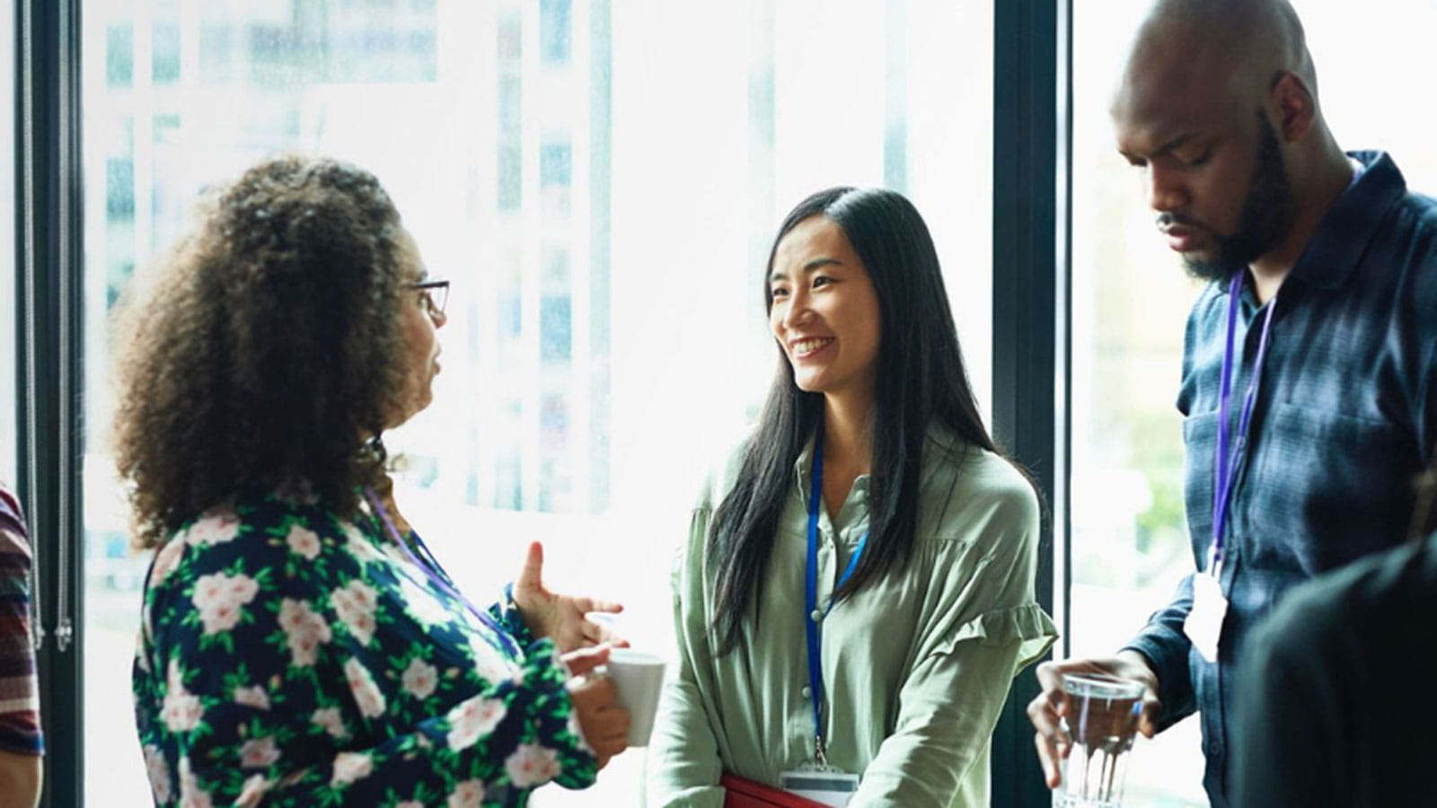 two women and a man in a corporate office having a conversation