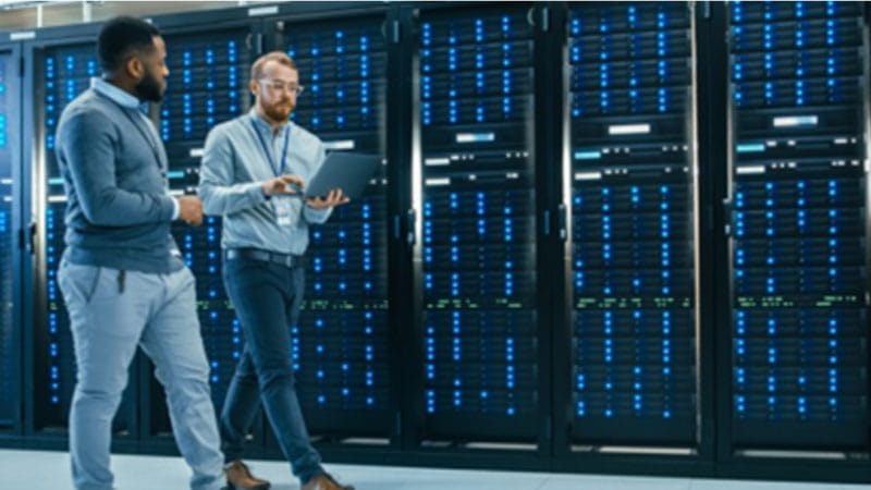 two men walking by a data center server 