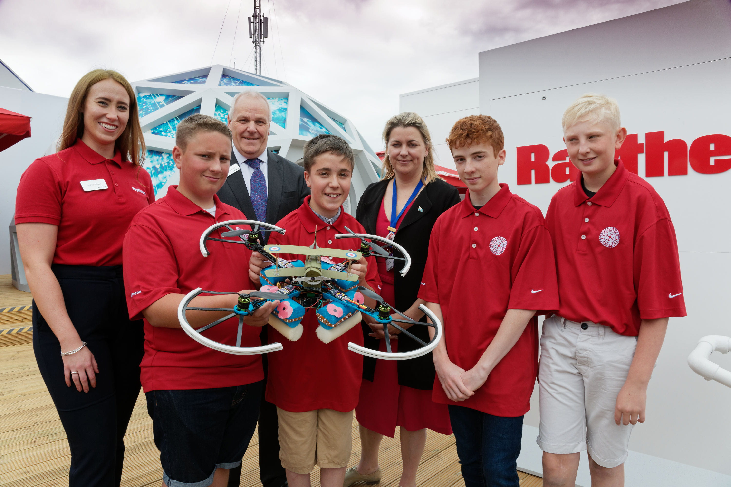 The 2017 Raytheon UK Quadcopter Challenge champions from Branston Community Academy display their award-winning design with Richard Daniel, Raytheon UK chief executive and managing director and Minister for Transport Baroness Sugg CBE at the 2018 Farnborough International Airshow.