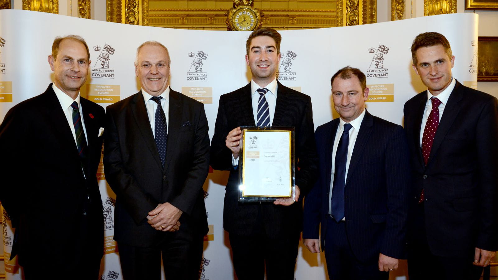Kevin Howard, chair of Raytheon UK Reservists and Veterans, holds the company's new Gold certification from the Ministry of Defence Employer Recognition Scheme for excellence in support of the armed forces community. From left to right: HRH The Earl of Wessex; Raytheon UK CEO Richard Daniel; Howard; Roland Howell, director of Airborne ISR; and Rt Hon Gavin Williamson, MP, Secretary of State for Defence.