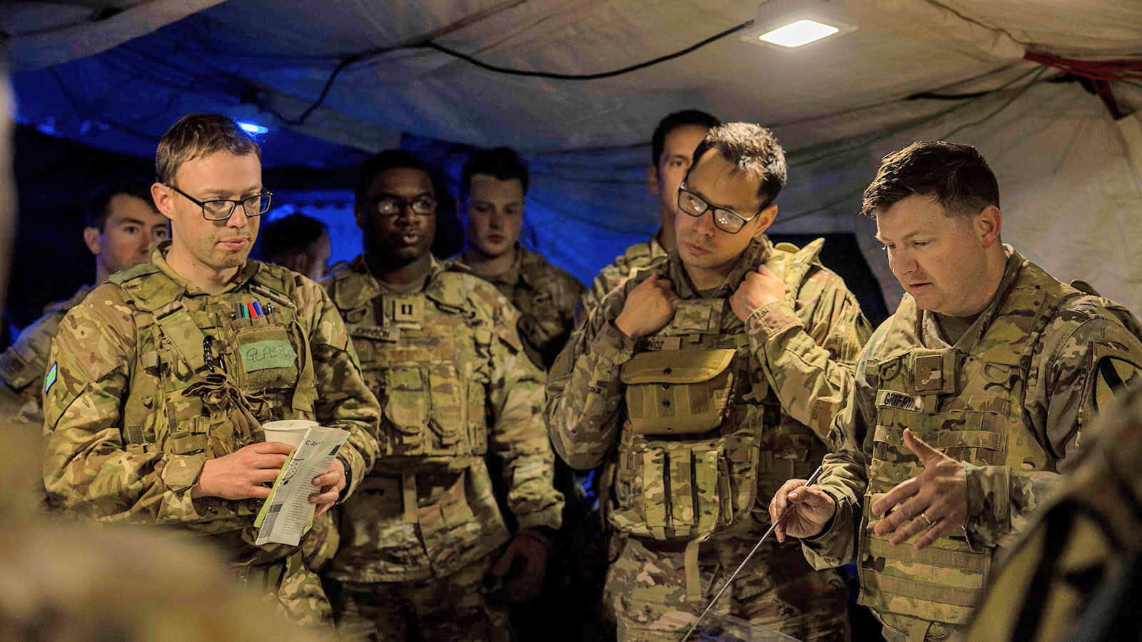 A group of troops discuss mission strategy during the training exercise. @Crown Copyright 2022