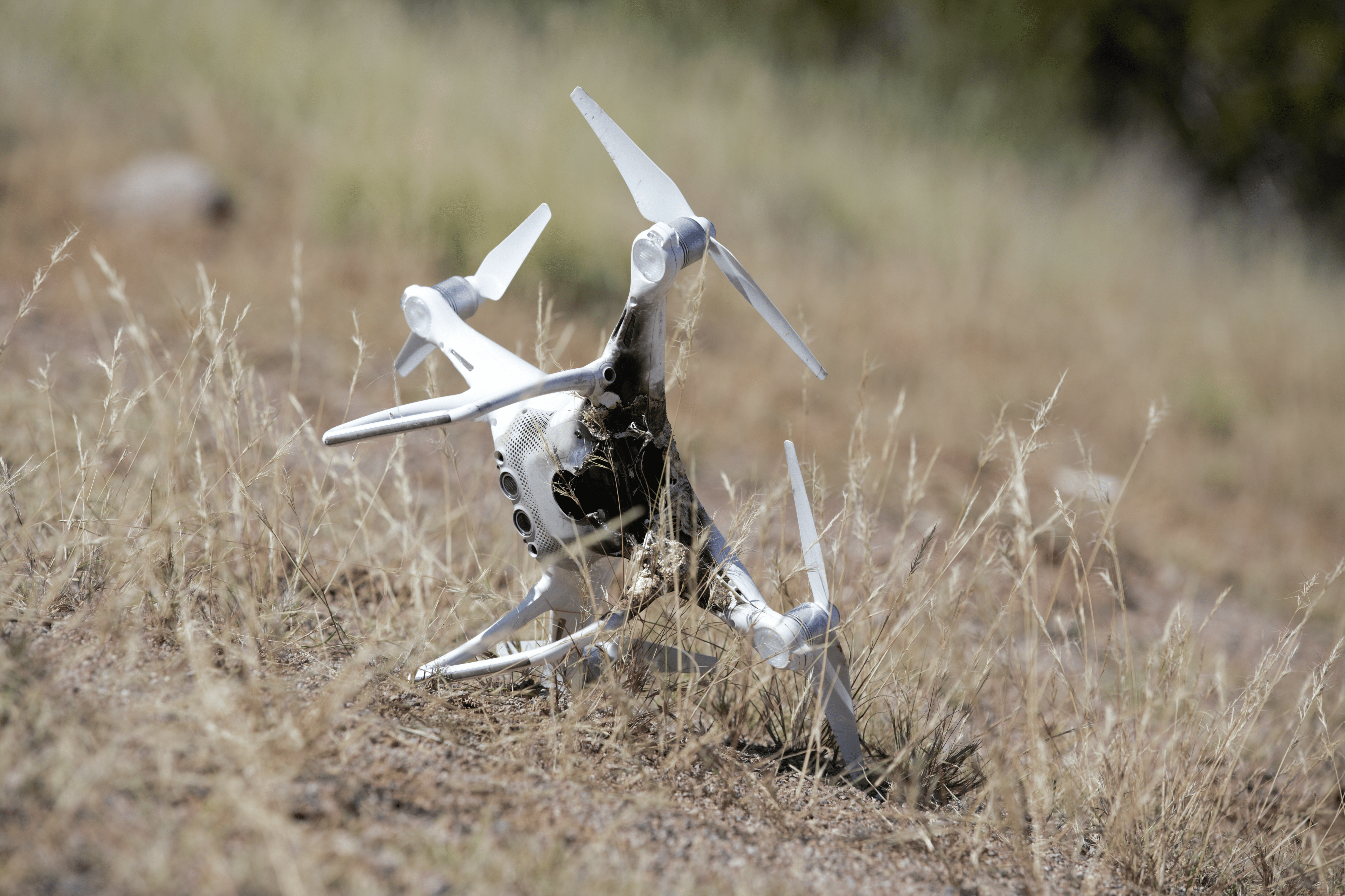 A downed drone lying in grass