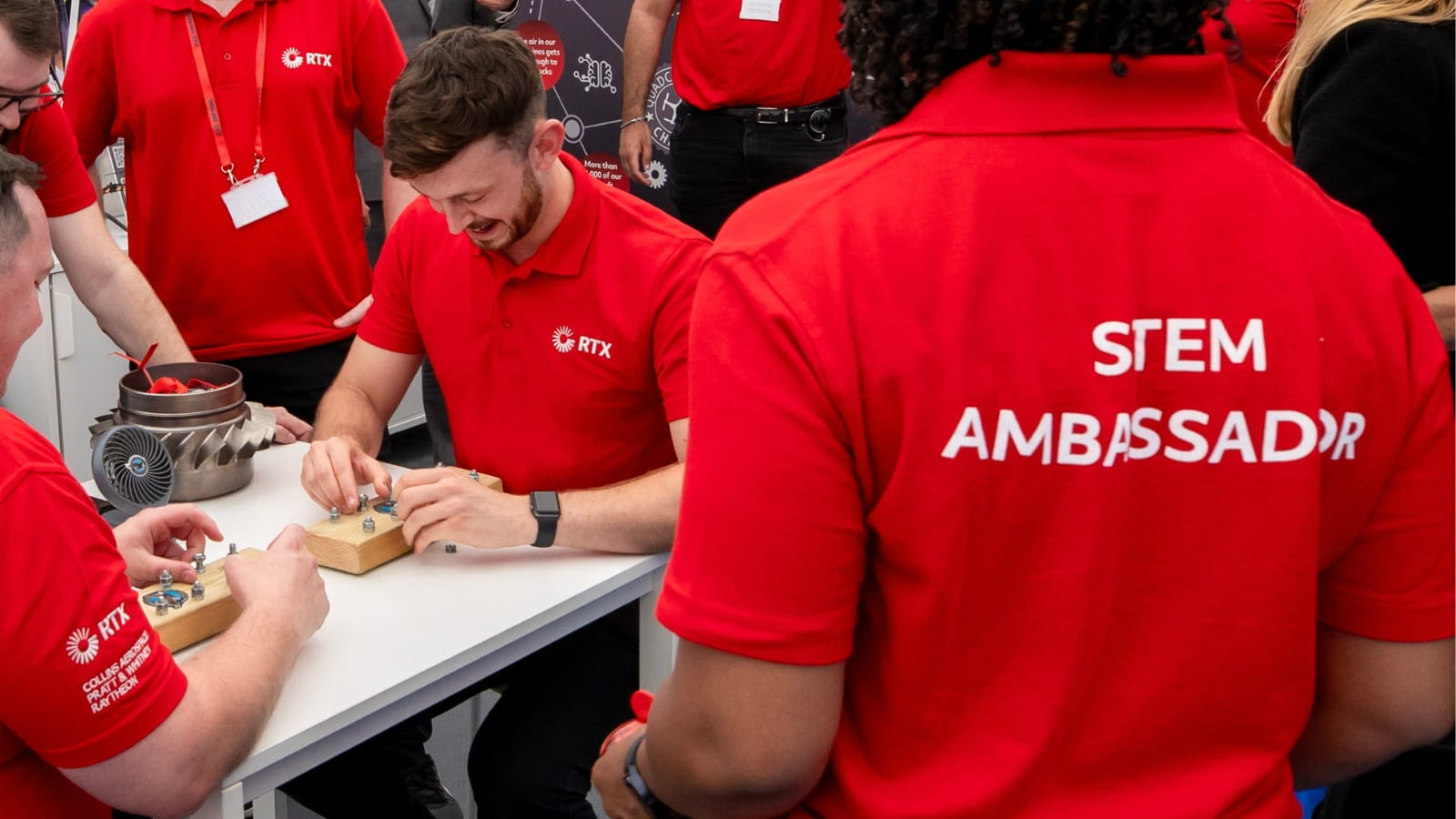 RTX Stem Ambassadors gather around a table to work on a Quadcopter