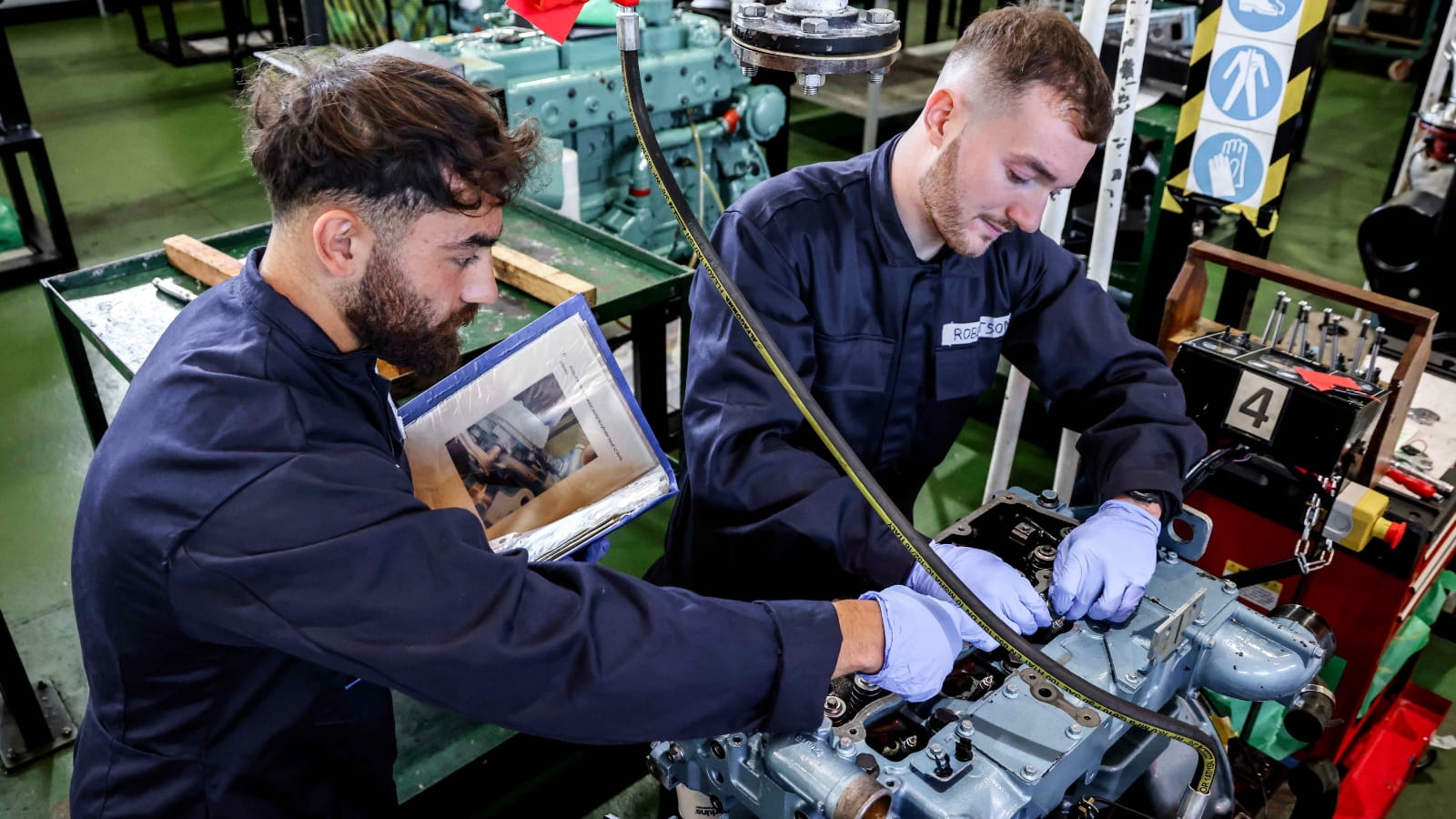 Two engineers work together on a piece of equipment