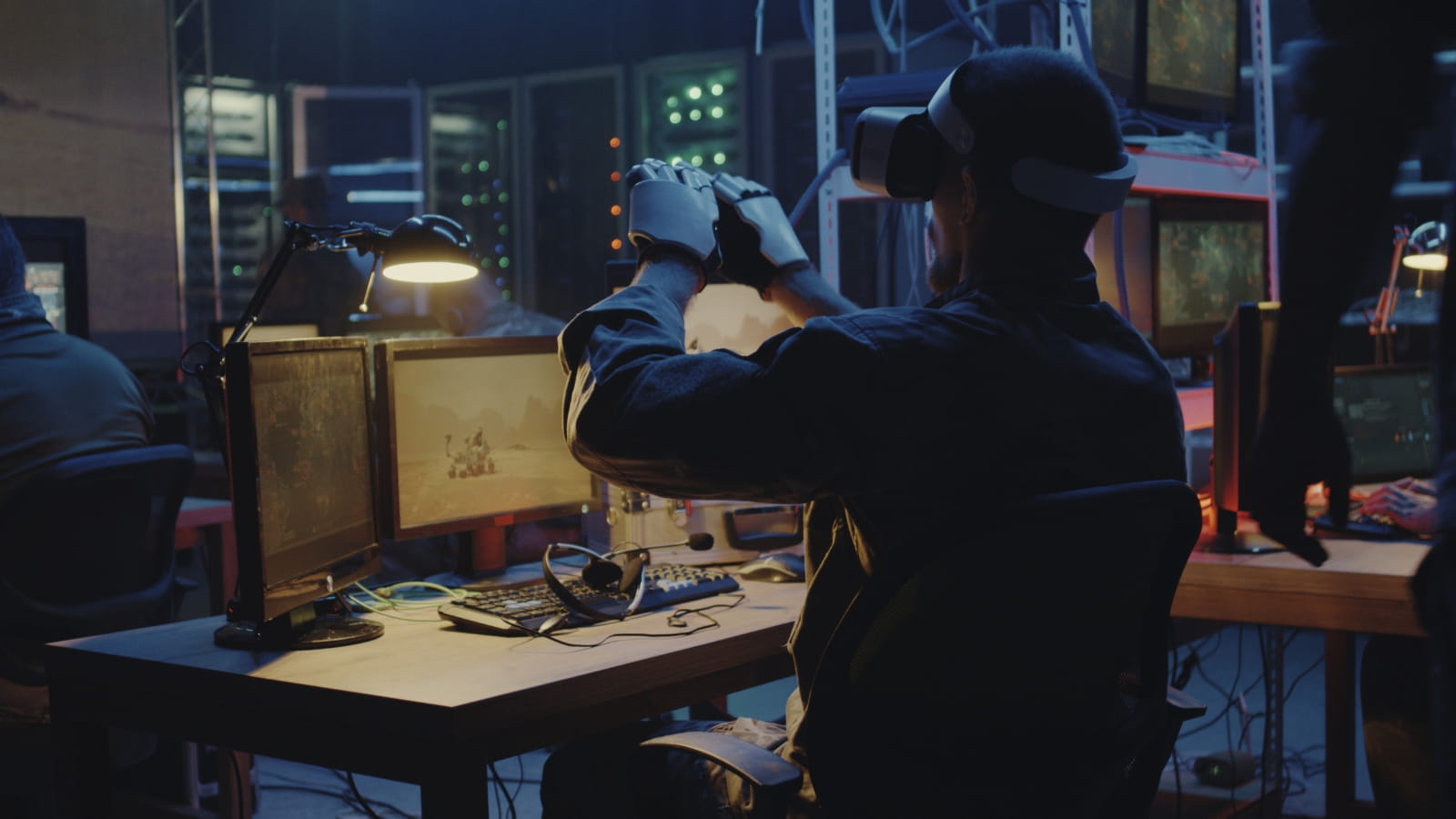 A soldier at a desk using VR headset and gloves