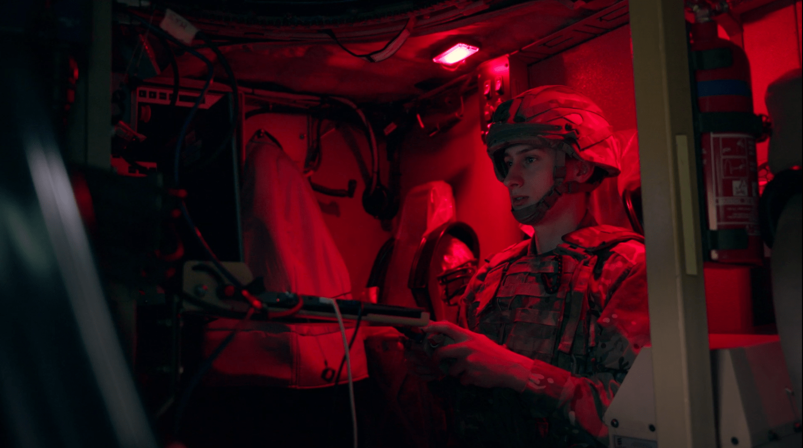 A British Army soldier performs a training task inside a military vehicle