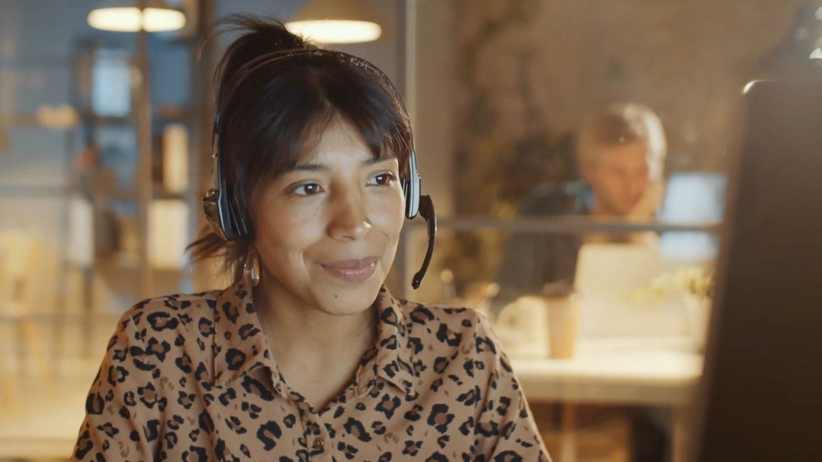 A woman with a headset sits in an office