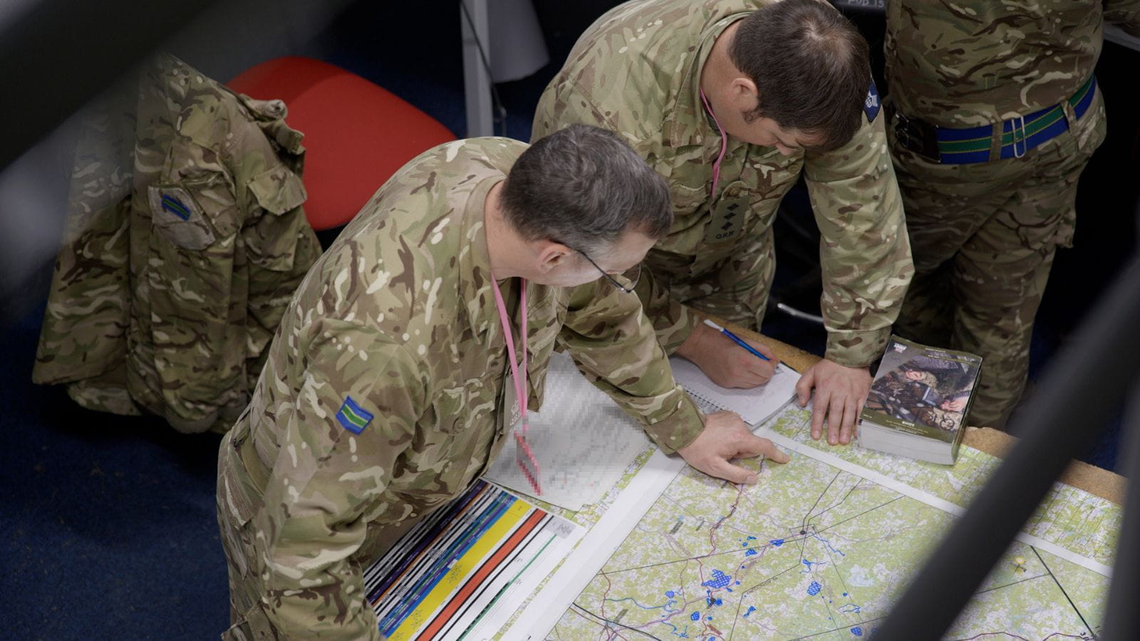 Army personnel mark a map during a training exercise