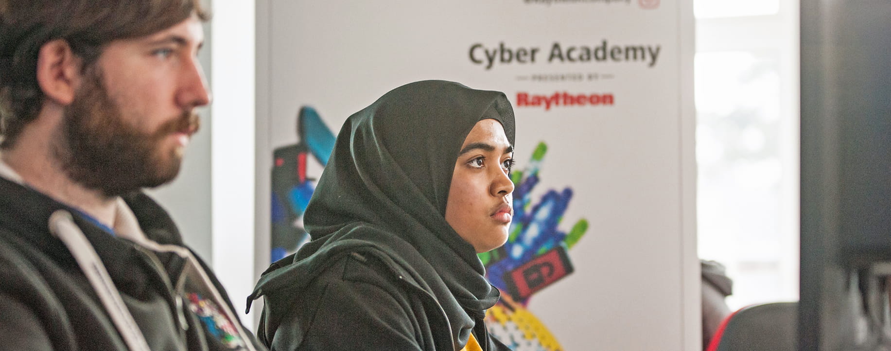 Two persons in Raytheon cyber academy