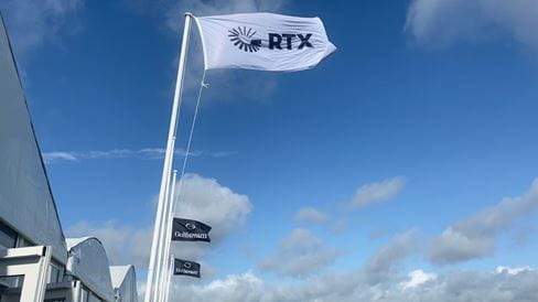 An RTX flag against a blue sky
