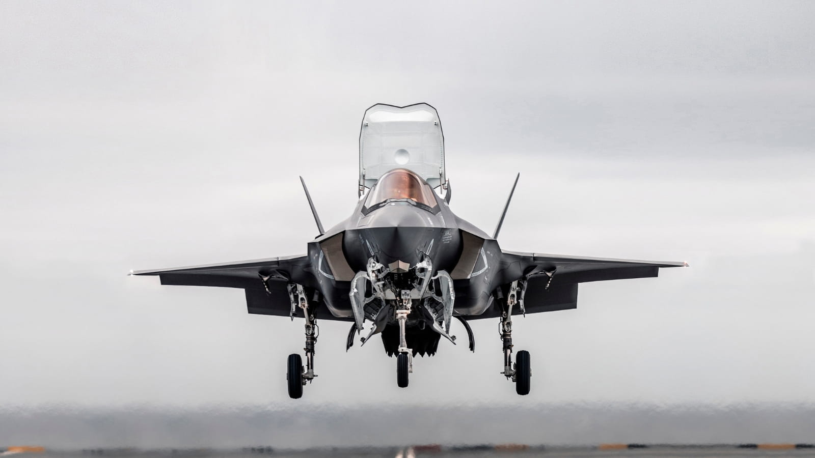 A fighter jet lands on a runway
