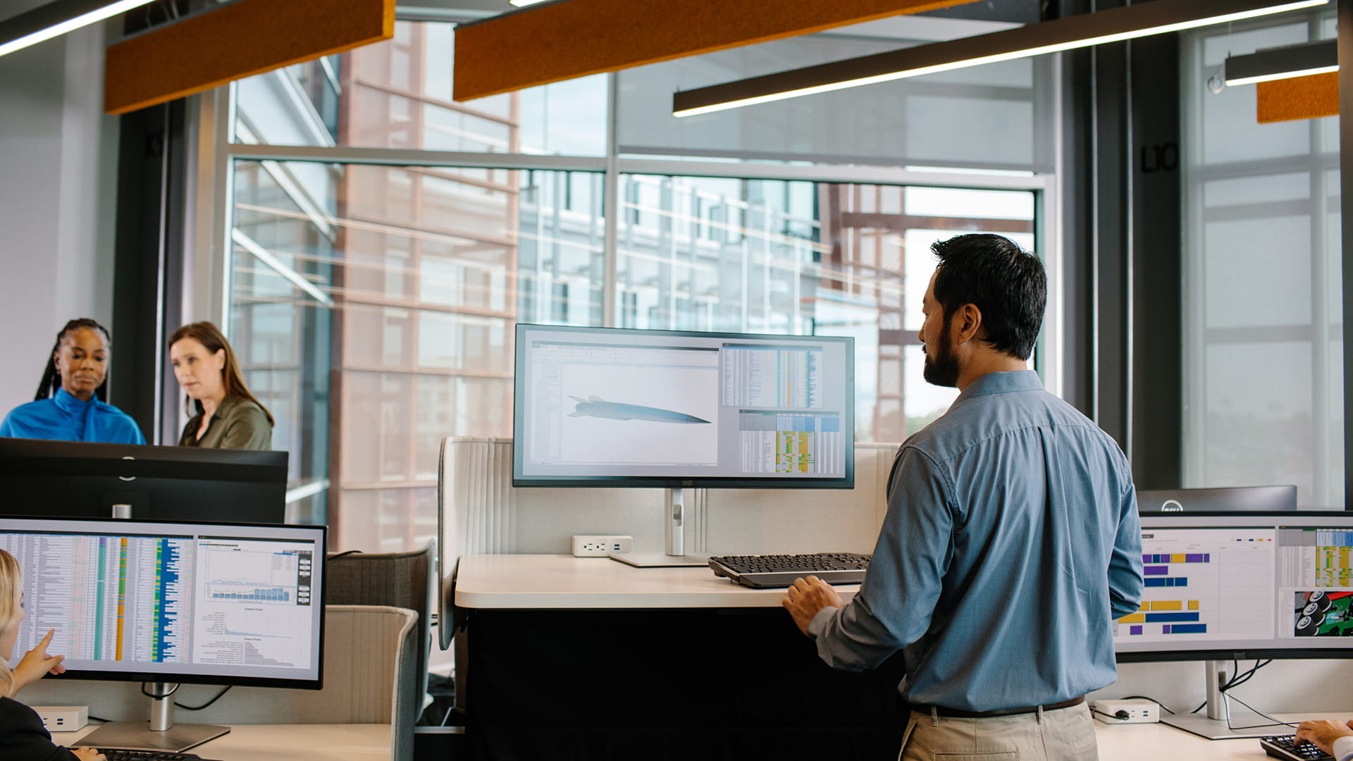 A man using a computer at a standup desk 