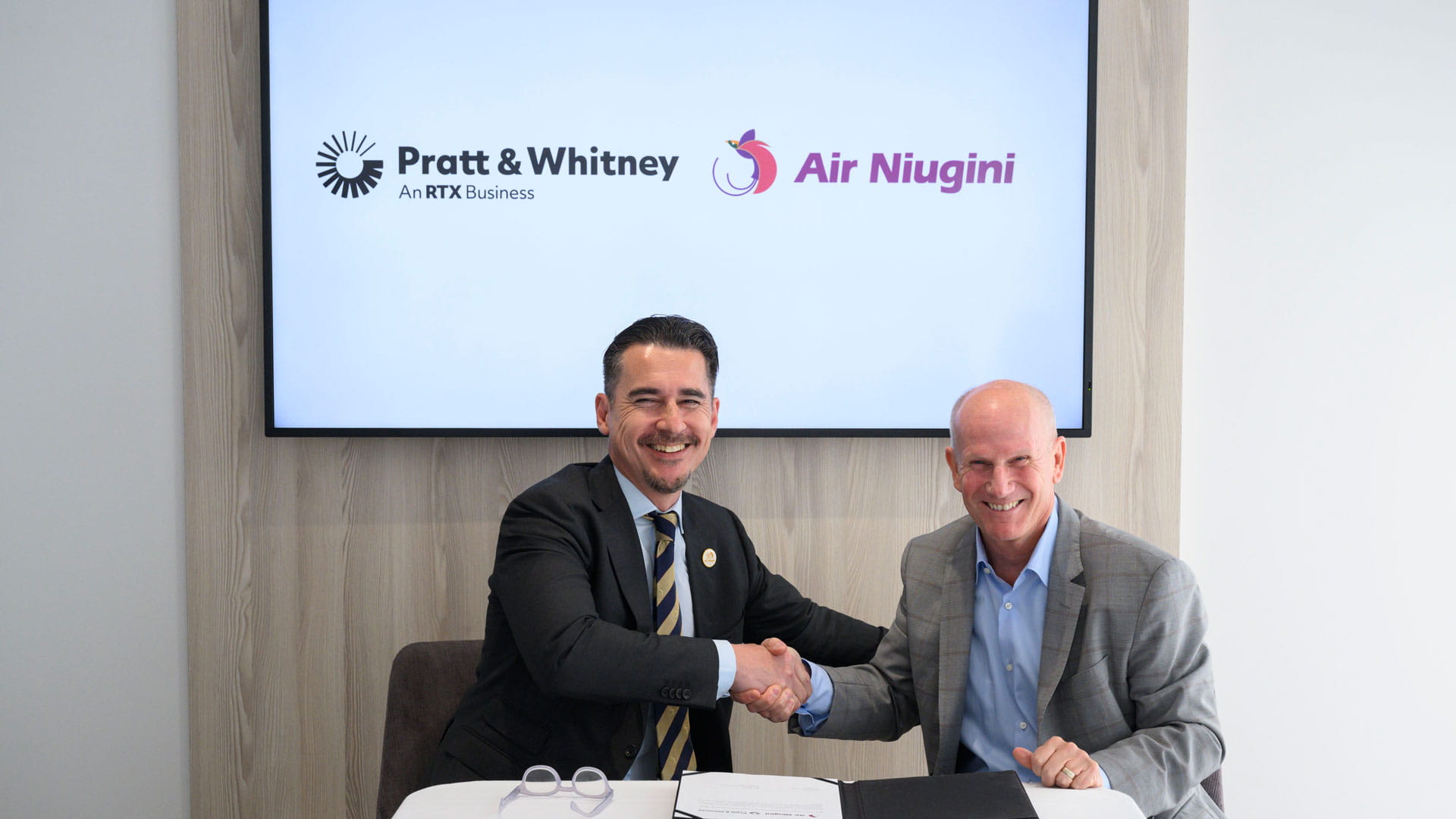 From L to R: Gary Seddon, chief executive officer of Air Niugini, and Rick Deurloo, president of Commercial Engines for Pratt & Whitney, finalize engine and aftermarket agreements for GTF engines to power 11 Airbus A220 aircraft for Air Niugini.   