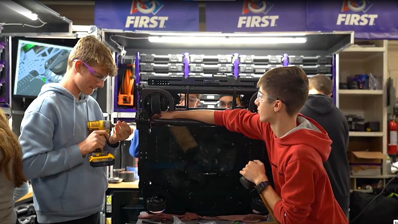 high school students work on a robot