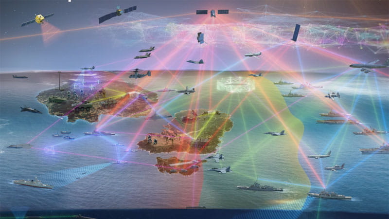 A computer-generated battlefield scenario illustrating network communication. The scenario includes satellites, naval ships, fighter jets and tanks.