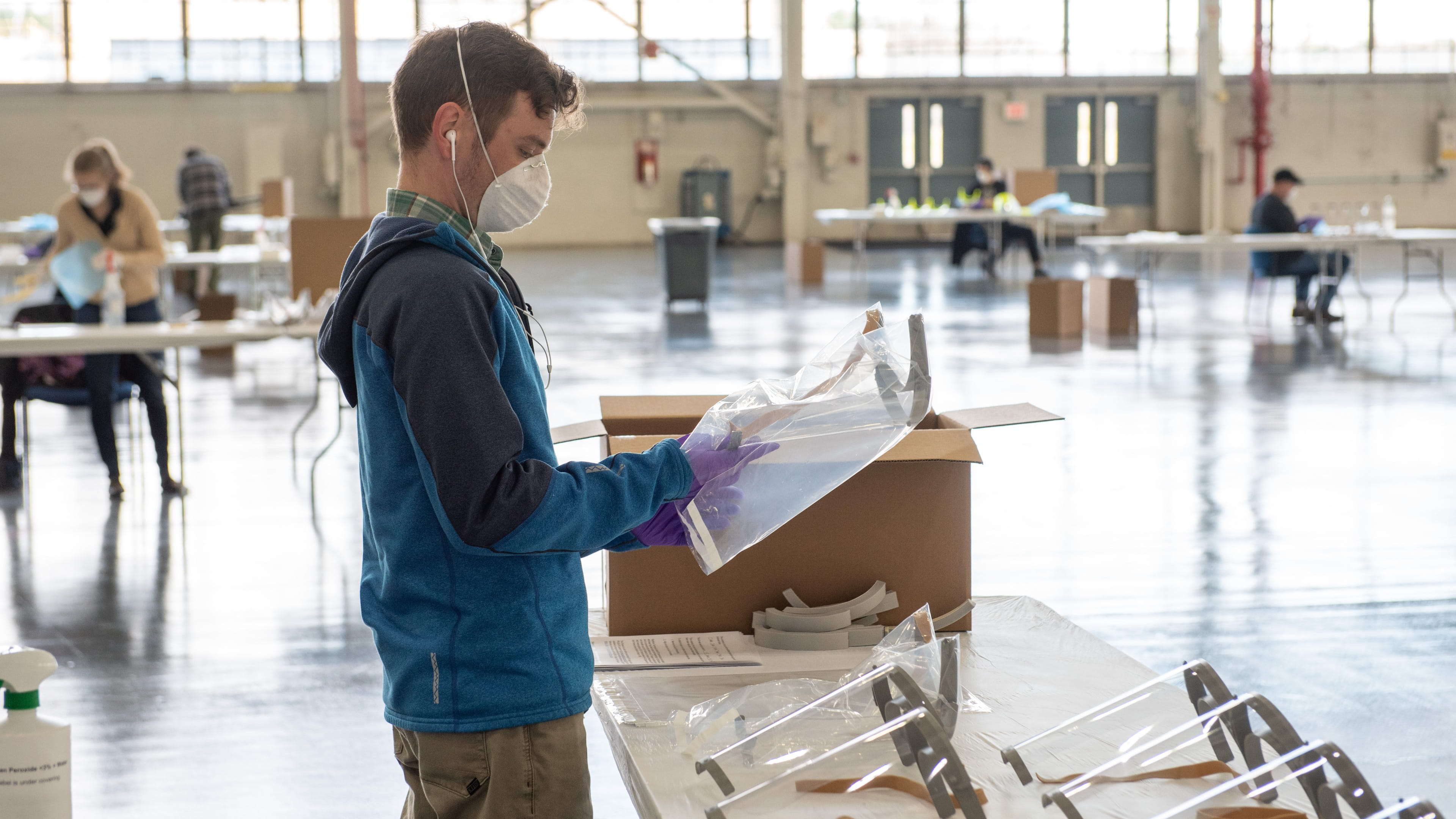 A Raytheon Technologies worker wraps an assembled face shield in preparation for shipping to COVID-19 first responders. The company is using 3D printing to manufacture components for the shields.