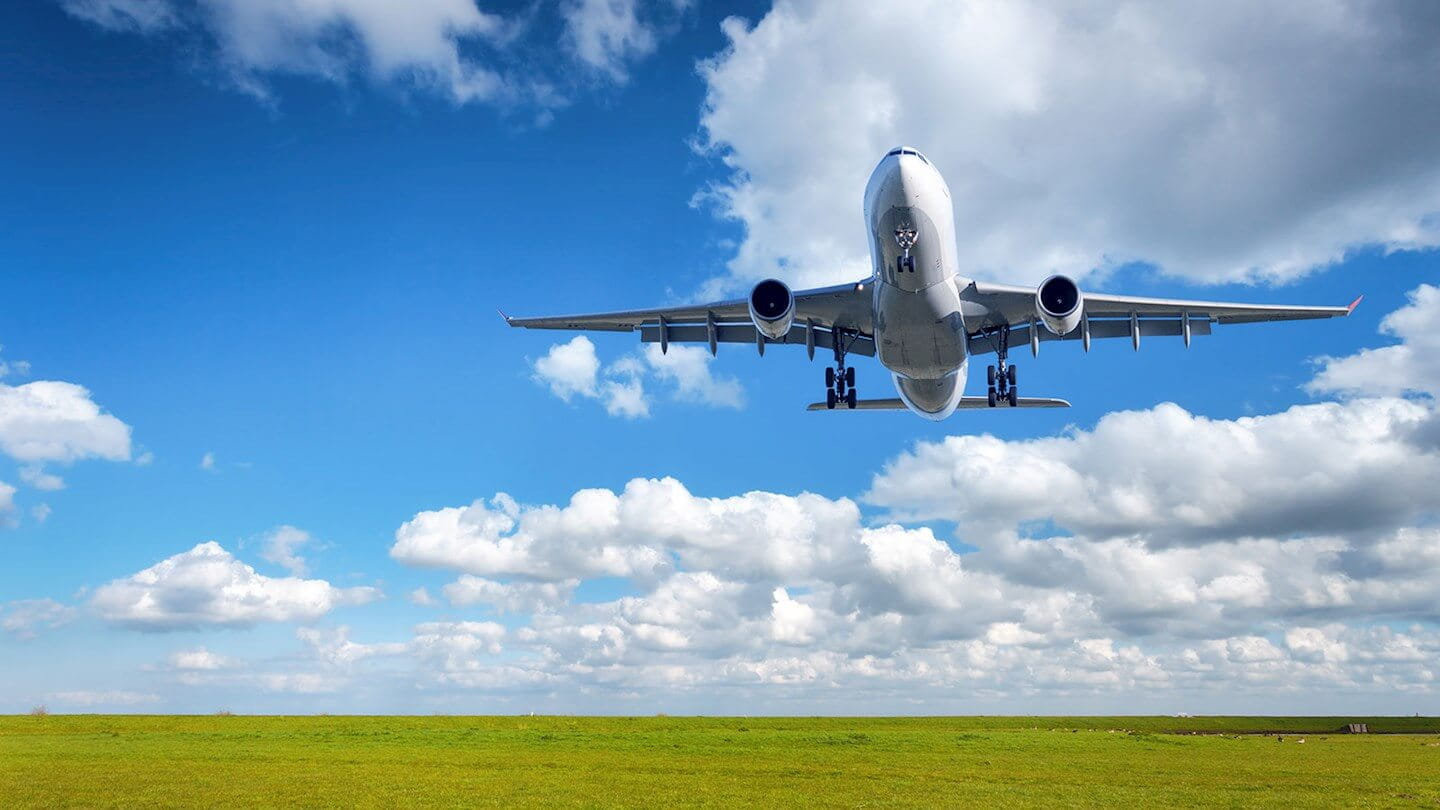 Plane flying over a field of grass