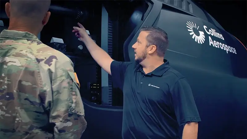 Employee showing a soldier the inside of a Collins helicopter