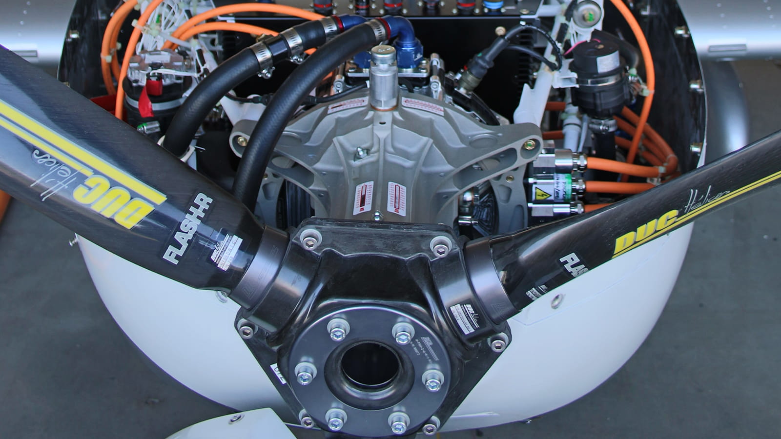 The inside of an aircraft propeller, with black and orange hoses connecting the various parts