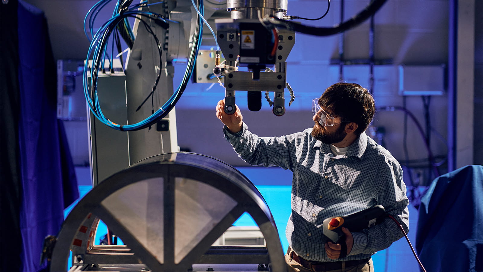 a technician inspecting a welding robot