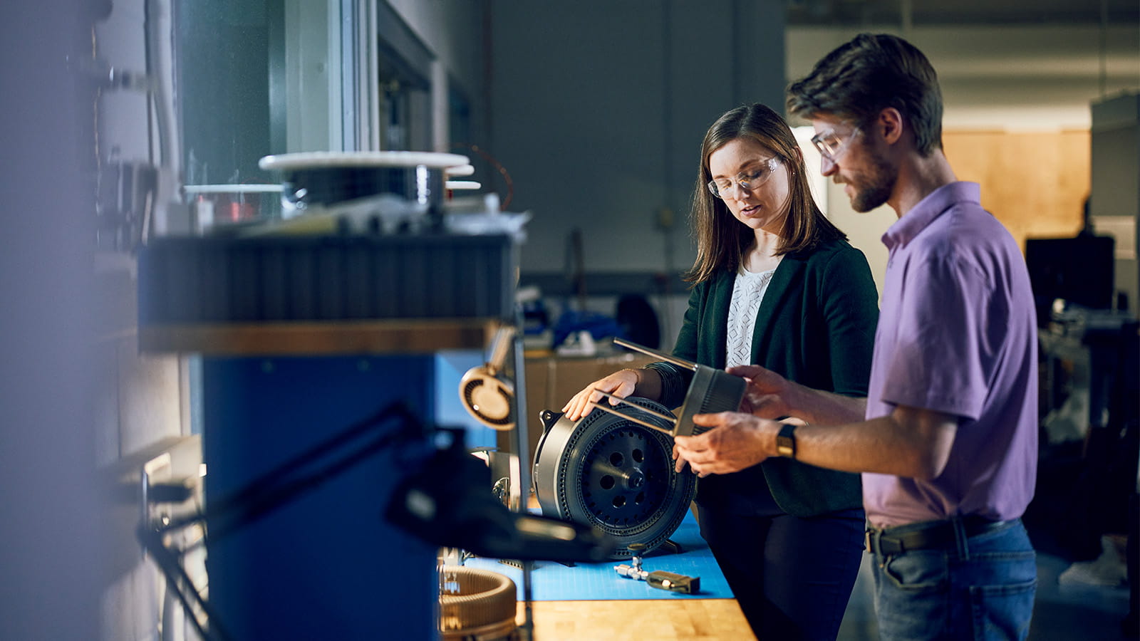two scientists inspecting a gear