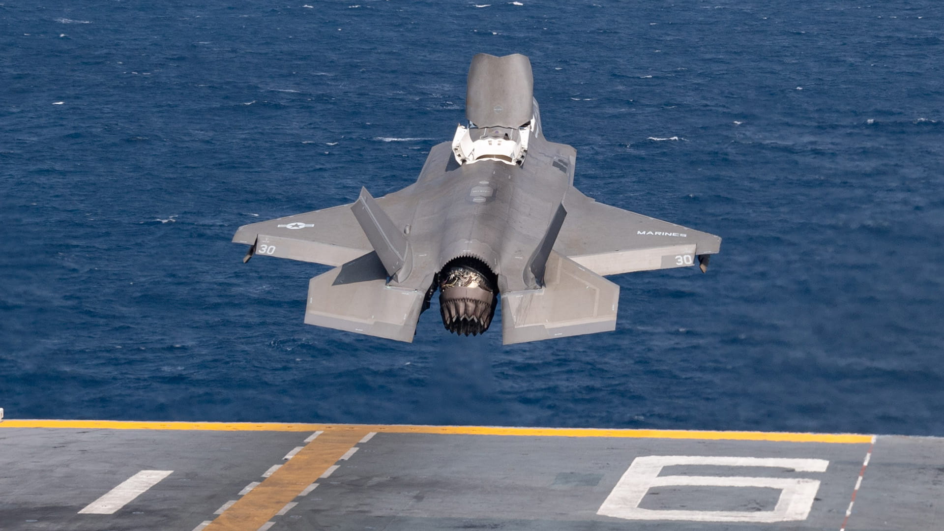 An F-35B Lightning II fighter aircraft takes off from the flight deck of an amphibious assault ship